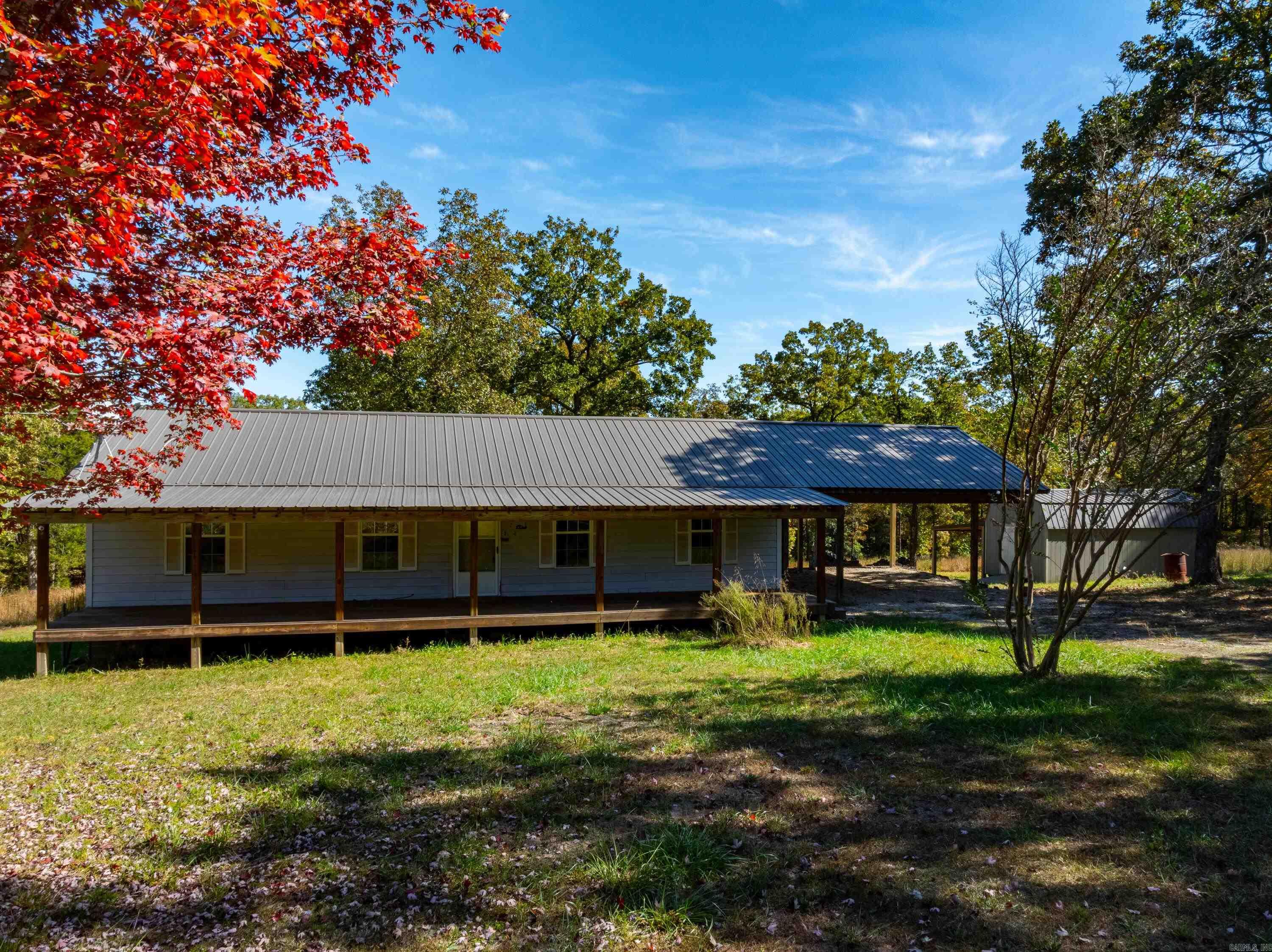 Sitting on 10 +/- beautiful acres, just 15 minutes from Cave City, Arkansas, this charming 3-bedroom, 2-bathroom home is the perfect blend of comfort and nature. With an attached carport and a front porch that spans the length of the house, you'll enjoy relaxing mornings overlooking the abundant wildlife that often visits the backyard.The back porch is also covered, making it a great spot to unwind and take in the peaceful surroundings.The home boasts a durable metal roof and a cozy outbuilding that can be used for storage or woodworking.As you step inside, you're greeted by a spacious living room that flows into the dining area.The kitchen is just off the dining room, offering plenty of cabinet and counter space, ideal for cooking. A laundry room conveniently sits next to the kitchen, with a door leading to the back porch ā a perfect setup for grilling or entertaining.Down the hall, youāll find two well-sized bedrooms, a craft room, and a full bathroom with a tub-shower combo. On the other side of the house, the primary bedroom offers privacy and comfort, complete with its own en-suite bathroom and direct access to the living area.Hunters paradise, room for livestock, Ozark Living