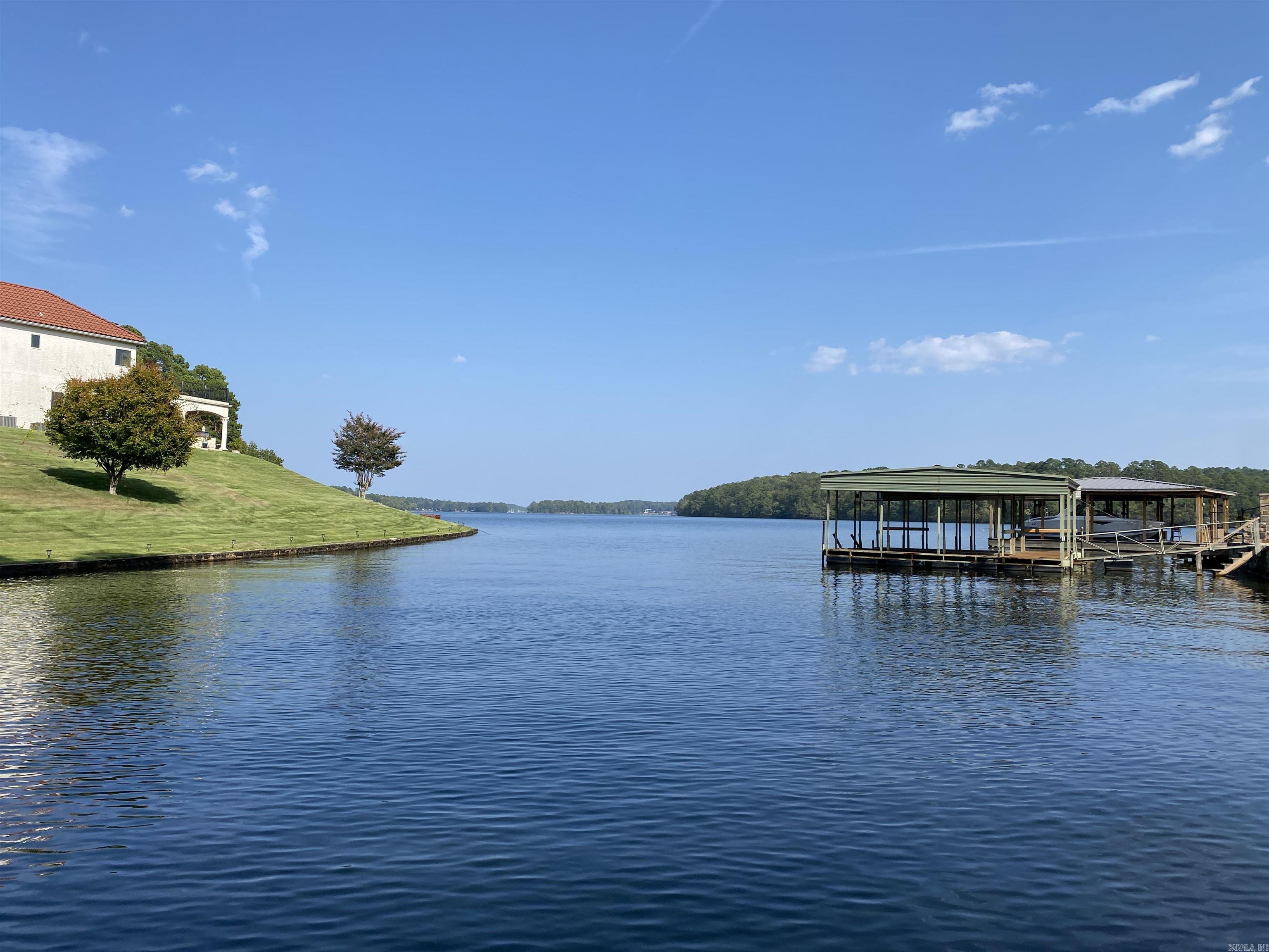 This may be the best deal on Lake Hamilton! This beautiful lake home has so much to offer. It has an amazing view of the lake and Garvan Woodland Gardens. New roof in 2023, New stationary covered boat dock, freshly updated kitchen, and so much more. The over 5000 sq' can be used as single-family living, or the lower level has everything it needs to be used as a separate living space with its own washer/dryer connections and garage entrance. Custom lake homes in upscale neighborhoods at $126/sq' is simply not a deal that you stumble across every day.