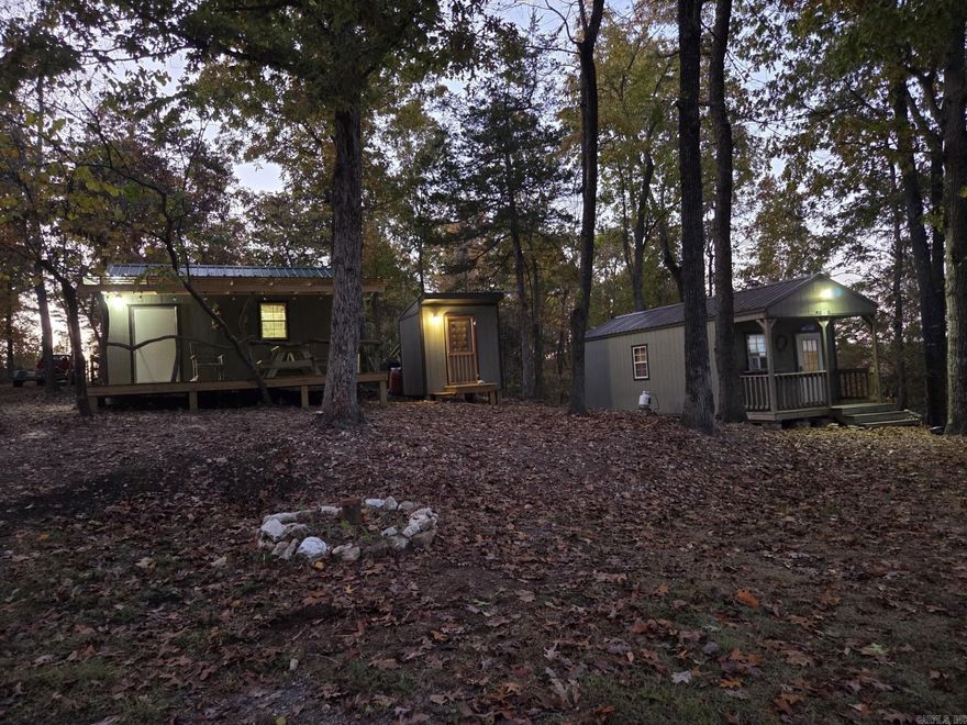 10 Acres Bordering The Sylamore National Forest – Turnkey Off Grid Cabin VRBO Escape to the Ozarks with this rare 10-acre property surrounded by The Sylamore National Forest on two sides, just minutes from Roasting Ear Creek. Private, peaceful, and fully set up as a successful VRBO-style getaway, this property is ideal for recreation, investment, or a personal retreat. The land features two charming Bald Eagle Barns: Main Barn – thoughtfully converted into a kitchen and bedroom Bunkhouse Barn – perfect for guests, with a spacious front deck for relaxing and taking in the scenery A separate bath house includes a sink, toilet, and walk-in shower, offering comfort while maintaining the rustic outdoor experience.  Additional highlights include:  Outside fire pit for evenings under the stars Excellent deer, turkey, and small game hunting right on the property, Private well already in place Secluded setting with direct access to thousands of acres of public land  Whether you’re looking for a turnkey short-term rental, a hunting basecamp, or a quiet off-grid-style escape, this unique property offers endless possibilities in a highly sought-after natural setting all for only 149,900.