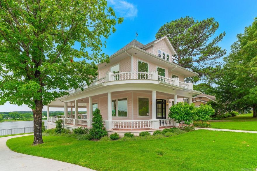 Perched high above the Arkansas River in Ozark, this beautifully restored 3,800 sq. ft. historic home offers some of the most breathtaking panoramic views in the Arkansas River Valley. Built in 1924 and completely remodeled, every area has been tastefully updated with all-new plumbing, wiring, and high-end finishes while preserving the home’s timeless character.  Designed for entertaining, the home features an easy flow from the welcoming front entry through expansive open living spaces to the oversized rear veranda, where sweeping river, bridge, and sunset views create an unforgettable backdrop. Large windows throughout the home capture the beauty of the river from nearly every angle, filling the home with natural light and spectacular scenery.  Rich in local history, the attic once housed the ferry captain who oversaw the Arkansas River ferry operation. Cozy nooks, private spaces, delicate touches of pink, two laundry rooms, and spacious living areas provide comfort and charm throughout.  Ideally located about an hour from Fayetteville and centrally positioned between Little Rock and Oklahoma City, with easy access to Dallas and Kansas City.