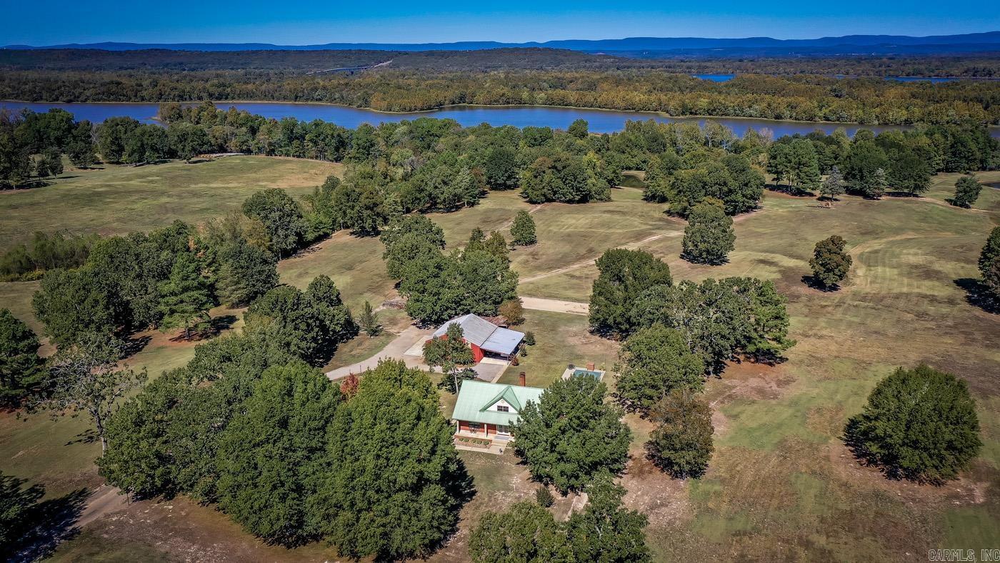 Escape to the serene beauty of rural Arkansas with this stunning farm property located at 745 River Port Rd, Scranton Arkansas. Embrace the tranquil lifestyle you've been dreaming of on this picturesque farm with 1/2 mile of Arkansas River Frontage within the boundary of Lake Dardanelle. The 2,499 +/- square ft home has 3 bedrooms, 2 1/2 bathrooms, and an in ground pool with a great space for entertaining. The home has concrete walls with brick exterior and concrete floors providing a quiet, comfortable, and safe location. The home has separate central heat and air units for each floor, keeping them comfortable year round. But the large wood burning fireplace in the living room provides a cozy space to relax during the winter months. The 74.71 +/- acre farm is currently being used for hay production but could easily be transitioned to a cattle operation with 3 ponds scattered around the property as well as some cross-fencing. The property even has an access gate for you to fish from the bank or launch your kayak to paddle around the waters of Lake Dardanelle. The property is teeming with wildlife, providing great viewing for hunters and those that simply like to observe.