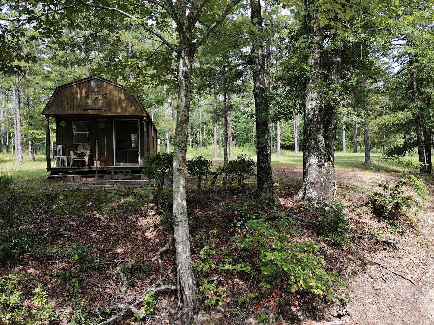Take a peek at this unforgettable Property featuring Cypress Creek running through the beautiful terrain of well kept land with fruit trees and other flowering plants splattered about with a serene cabin tucked away. Front gated part hosts a large Barn/ shed and other parts of this property have timber. Must see to appreciate.