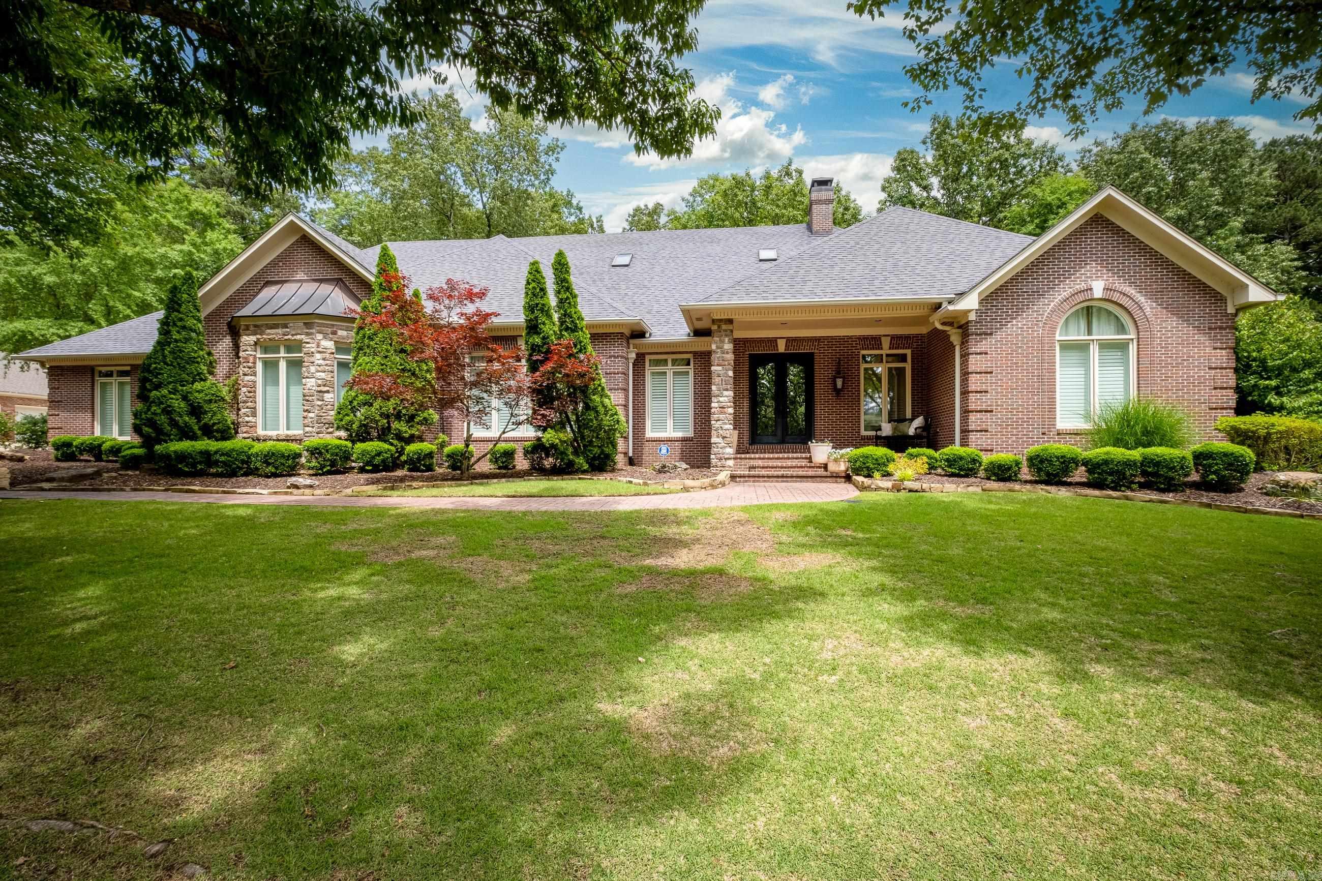 This stunning custom home on the prestigious Founder's Course of Chenal Country Club offers a perfect blend of elegance and functionality. Enter through the striking iron and glass doors to an open floor plan designed for both family living and entertaining. The living room boasts exotic wood floors, a beautiful fireplace, and breathtaking golf course views. Adjacent to the foyer, the formal dining room flows into a spacious kitchen with a center island, high-end appliances, and a cozy informal dining area. A family den with a fireplace opens to a large, bricked patio, ideal for outdoor gatherings. The main level features a luxurious principal suite, guest suite with walk-in closets, and a versatile home office/media room with a half bath and wet bar. Upstairs, enjoy a spacious game room, three bedrooms, each with direct bath access, and an abundance of attic storage. The beautifully landscaped yard includes a water feature and the home is complete with a three car side-loading garage, and golf cart garage with ample storage. Enjoy the golf course with direct cart path access right from from your own driveway! Come see this meticulously maintained gem today!!