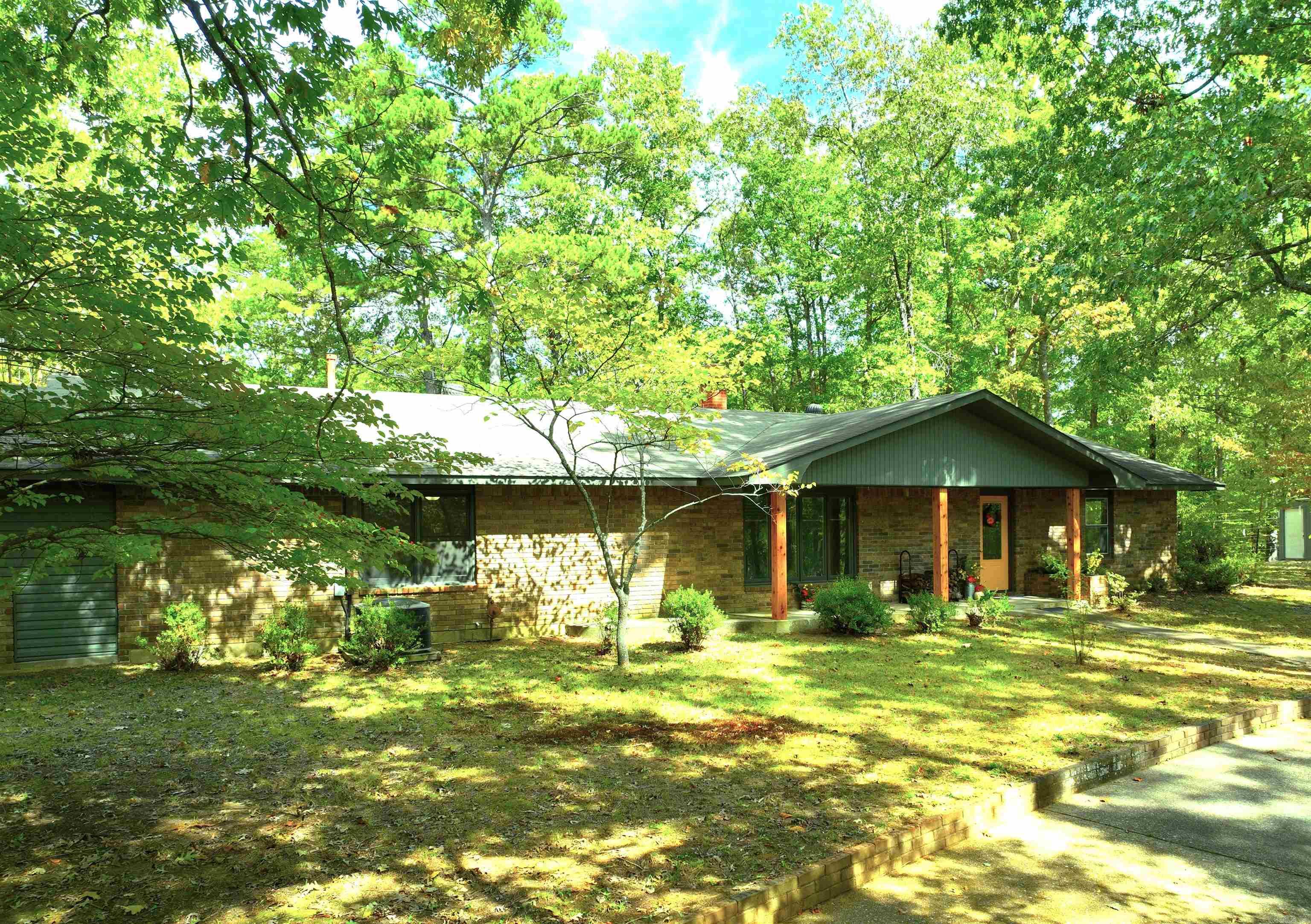 Hidden from View, this treasure is tucked into 6 pristine acres of Pine, Dogwoods, & Oak. The 3 bedroom, 2 bath, fully renovated ranch style home is only minutes from Mena. Resplendent with luxury features, the neutrally toned house has a spacious living room with a wood-burning fireplace & locally sourced hand carved mantle, an entire wall of built-in buffet & cabinetry, a well-appointed chef's kitchen with all stainless steel appliances, soft close drawers, granite countertops, huge island with under-counter storage & barstool seating, & a gracious dining room with access to the expansive, tiered outdoor deck & hot tub experience. The oversized primary suite has ample room for a sitting area, & includes a walk-in closet, mounted television, bath with double vanity, & linen closets. Behind plantation doors, the laundry & additional stylish storage shares the hallway space. Additional voluminous 2 bedrooms & bath finish the interior. A 24x40 studio/shop features bay doors, storage closets, heating & air, open area for multiple tasks, plumbed for a kitchen & a half bath for convenience. Apple, peach, cherry, & pear trees should soon produce their bounty. Separate 16x24 shop.
