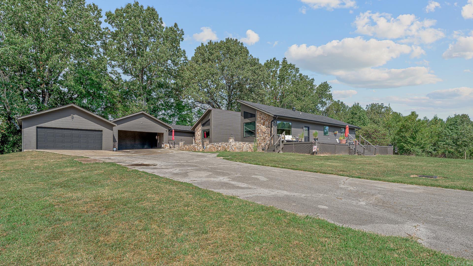 This breathtakingly transformed 3-bedroom, 3.5-bathroom home offers the perfect blend of modern elegance and serene country living. Situated on a private lot, enjoy peaceful moments with frequent visits from local deer, and the option to purchase an additional lot. Step inside to find a fully updated interior with high-end finishes throughout. The split plan design ensures ultimate privacy, with a luxurious Primary Suite retreat. This expansive bedroom features direct access to a private side deck, and a fireplace a walk-in closet, and an en-suite bath designed to impress: a tiled shower, slipper tub, double vanity, and plenty of storage.The island kitchen is a true showstopper, boasting Corian countertops, a wall of pantry storage, and both a dining room and breakfast bar. A built-in buffet with glass cabinetry adds a sophisticated touch. The spacious living room and large great room provide ample space for gatherings, while the guest suites each feature their own private baths for comfort and privacy. Additional highlights include a half bath in the hall, a small office nook off the back hall perfect for work or study, and a detached shop for hobbies/storage