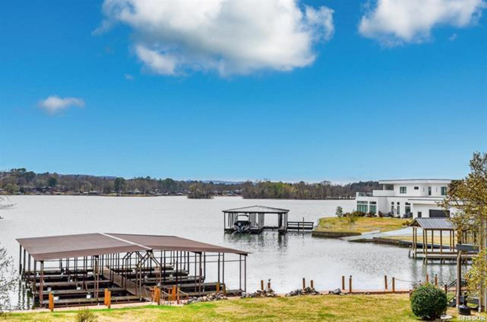 Discover the rarity of a three-bedroom lakefront condo nestled along the waters edge of Lake Hamilton. Just a leisurely three-mile drive to Oaklawn Racing and Casino, this home offers panoramic vistas of the tranquil waters and Beautiful Vista Views, all within a picturesque, part-like setting. Step inside to find hardwood floors that exude timeless elegance, complemented by a stunning stacked stone fireplace that serves as the heart of the home. Granite countertops adorn the kitchen, adding a touch of sophistication to every culinary endeavor. Unwind on the full-length deck, where the sparkling pool below invites relaxation amidst the serene surroundings. A mere 100-foot stroll leads you to the tranquil shores of the lake, offering endless opportunities for recreation and rejuvenation. Enhanced with upgraded windows to capture the breathtaking views, this condo promises a lifestyle of unparalleled luxury and tranquility. Please note that short-term rentals are not permitted, ensuring a serene and exclusive retreat for residents to savor.