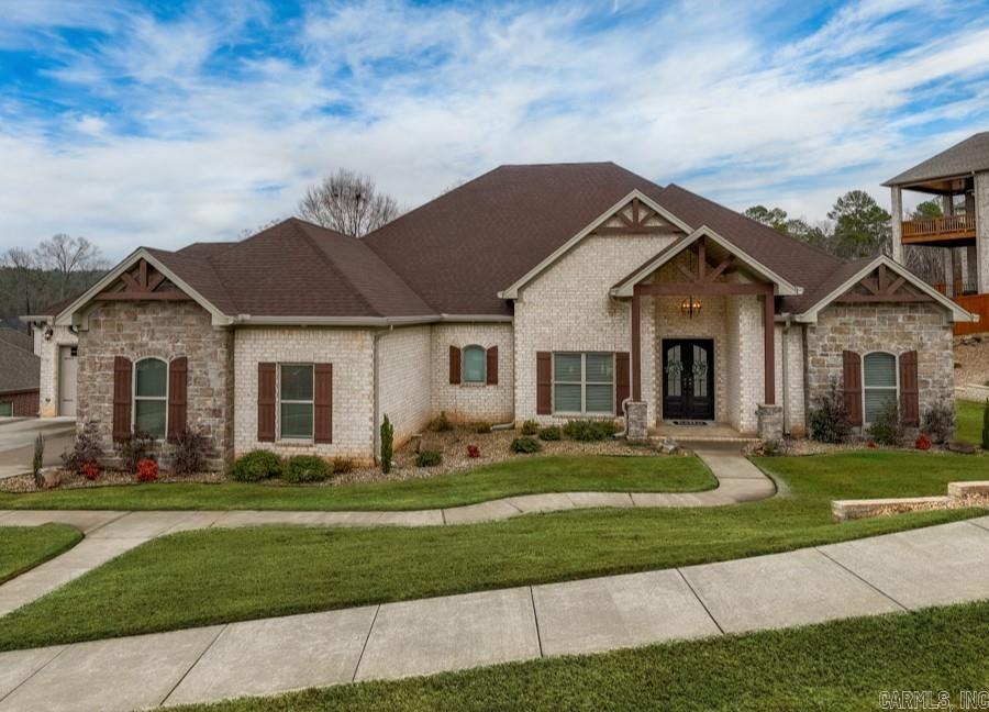 You'll love the unique features of this stunning custom-built home in Maumelle Valley Estates! Thoughtful details shine from the moment you step through the iron and glass doors into the living and dining area, featuring arched brick and shiplap accents. The chef’s kitchen boasts a 6-burner gas stove with griddle, double ovens, pot filler, two islands, built-in ice machine, and walk-in pantry—all with a perfect view of the kidney-shaped saltwater pool and tanning deck. A cozy hearth room features a beautiful brick fireplace with a custom mantle. The spacious owner’s suite offers a cast iron clawfoot tub, walk-in shower, under cabinet lighting, and a boutique-style closet with space for hundreds of shoes! Three additional spacious bedrooms provide comfort and flexibility, with extra storage throughout. You'll love the screened porch with a fireplace and pool views. The laundry room has space for a second fridge, a sink, and ample cabinetry. The oversized 4-car garage is heated/cooled with an attic lift for easy storage. Situated on a large, beautifully landscaped lot. Geothermal heating system for efficiency. Agents see remarks and docs for full list. Preapproval required to show.