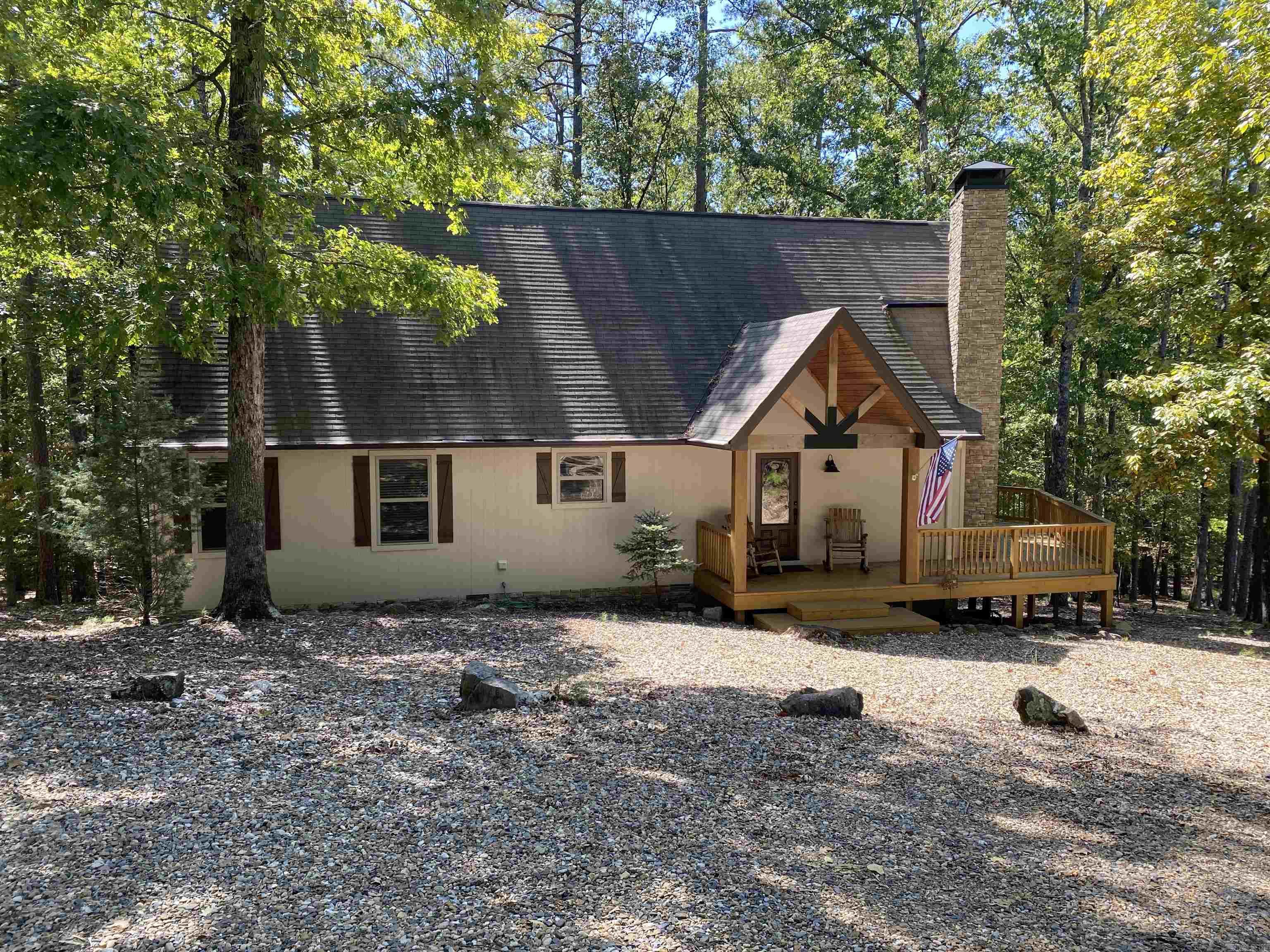 This home is a must see! If you have been searching for your Lake Ouachita getaway at Mountain Harbor Resort, you don't want to miss this one. Approx. 1,716 sq ft in the main home with 3 bedrooms, 2 baths and extra sleeping in the loft. Tongue & groove vaulted ceiling with a wall of windows to bring in that natural light and a wood burning fireplace for these cool fall nights. Screened back deck with vinyl curtains and TV already in place and an open deck for grilling. Underneath, the home is fully encapsulated and is a perfect place for storing the necessary lake toys or parking the side by side. The guest house has approx. 696 sq ft and includes a bedroom, bath, kitchenette, living area, more sleeping space in the bunk beds and attached carport! Nicely furnished with everything thing you need to start enjoying the lake life! Sits on 1.42 acres (+/-) in Harbor South. This is a one owner home that has been loved by its family and it shows! Call today for your private showing!