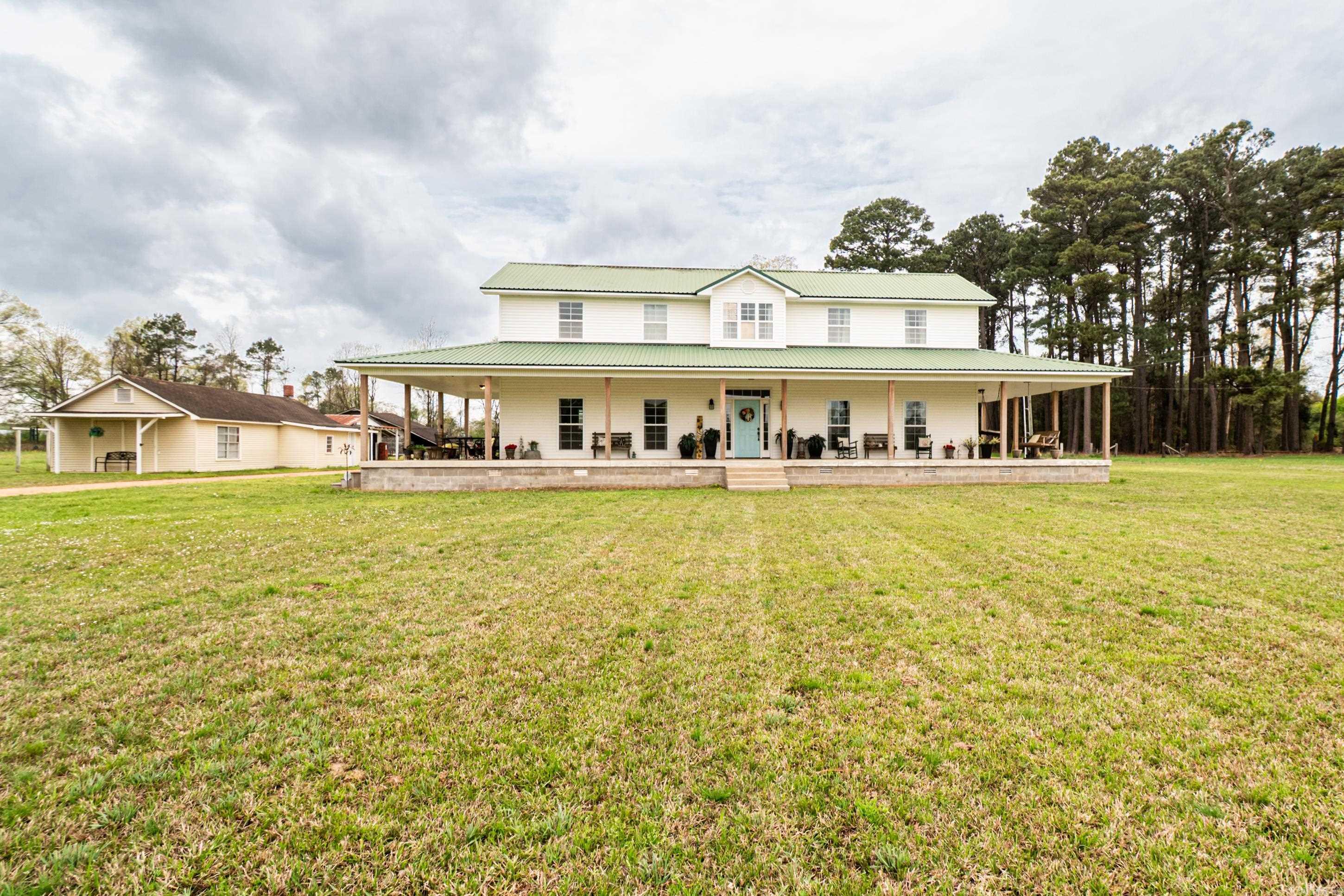Just Listed! Stunning Remodeled Farmhouse on 10.15 Acres – 712 US Highway 63N, Warren, AR Welcome home to this beautifully remodeled 4,174 sq. ft. farmhouse nestled on 10.15 acres of serene countryside! This 4-bedroom, 4.5-bathroom home is filled with charm, featuring solid wood plank walls throughout the living spaces, giving it the perfect farmhouse feel. * Property Highlights: * Spacious Layout – Includes a family room, formal dining room, large kitchen, and library * Mother-in-Law Suite – Complete with living room, kitchen, bedroom, and bathroom * Farmhouse Charm – Solid wood plank walls in key areas, adding warmth and character * Lovely Wrap-Around Porch – The perfect spot to relax with a porch swing to enjoy the peaceful surroundings * Outdoor Features – Two storage buildings (one with a half bath), an old barn, and a 30x30 shop * Authentic Touches – Solid cypress posts on the front porch& carport, sourced from a local sawmill This one-of-a-kind property offers modern comforts with timeless charm—perfect for those looking for space, privacy, and character.
