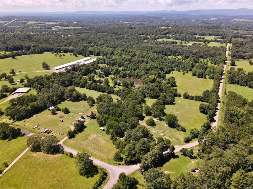 Located just minutes from Interstate 40 and Piney Bay, this family farm has been lovingly operated for three generations and is now ready for its next chapter. With county road frontage on two sides, this property offers both convenience and accessibility, whether you envision continuing its agricultural use or exploring its development potential. The land unfolds across gently rolling terrain, with a well-balanced mix of fertilized pastures and timbered areas that offer ideal grazing and natural shade for livestock. The entire property is fenced and cross-fenced, with multiple gated entrances, making it well-suited for rotational grazing or expanding herd capacity. Water is abundant thanks to two ponds and a creek, which provide reliable year-round sources for animals. A collection of working farm infrastructure supports the property's functionality, including working pens, a chicken coop, a dog kennel, and multiple storage outbuildings for equipment and supplies. The 3-bedroom, 1-bath farmhouse has been the family’s homeplace for decades and still carries the welcoming warmth and charm of simpler country living.