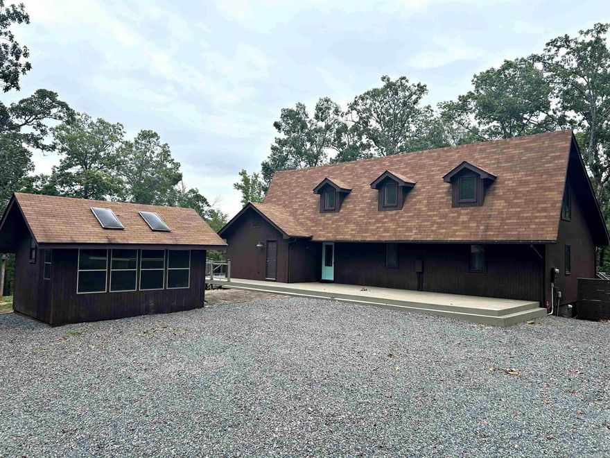 Looking for a secluded hideway with amazing views, this home is a must see! Spacious 3,703 sf home sitting on 15.37 acres partially manicured, partially wooded  near Caddo Valley, Arkadelphia and Degray Lake. If you prefer the quiet enjoyment of country living, stay home to enjoy the batting cages on concrete pad, greenhouse, chicken coop or Little Degray Creek area, all onsite.  This home contains 4 bedrooms, 2 full and 2 half baths, an update primary suite with woodburning fireplace (2018), beautiful new kitchen with quartz countertops (2021), sunroom, office, basement area with second family room, wine cellar and walkout patio with hot tub.  Lots of storage inside and out.  Multi-level decks for outside entertaining, front of home has new composite deck.