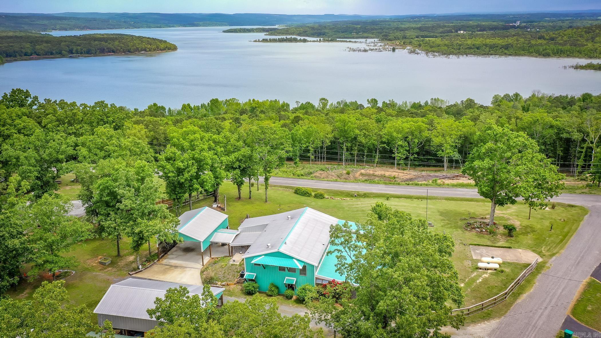 Stunning Panoramic views of Greers Ferry Lake overlooking Higden Bay! A total of 8 lots including approximately 4 acres!!(4 lots with the home & 4 lots across the street to maintain your amazing lake & vista views! This property is so unique & one of kind, you won’t find another one like it.The sellers have lived here full time since home was built & includes whole house backup Generac Generator (done by Mr. Sparky & on its own propane tank that will stay), Clean Storm Shelter, a huge sleeping porch with a 1/2 bath & setup w/kitchenette space including sink, refrigerator, TV, washer/dryer, bed, & Bistro Table (such a cool space, you must see.Wood burning stove can be negotiable for separate price).The Cabin will come mostly furnished (sellers have some personal items that won’t stay throughout like the bedroom furniture in the downstairs bedroom that was seller’s moms & some other select items). All kitchen appliances in the home will stay including the gas space heaters. Home has central heating & air,24x30 attached carport , 30x50 detached garage, RV hookups, Primary Bedroom has walk out screened porch off sliding glass door, & oversized walk in shower.