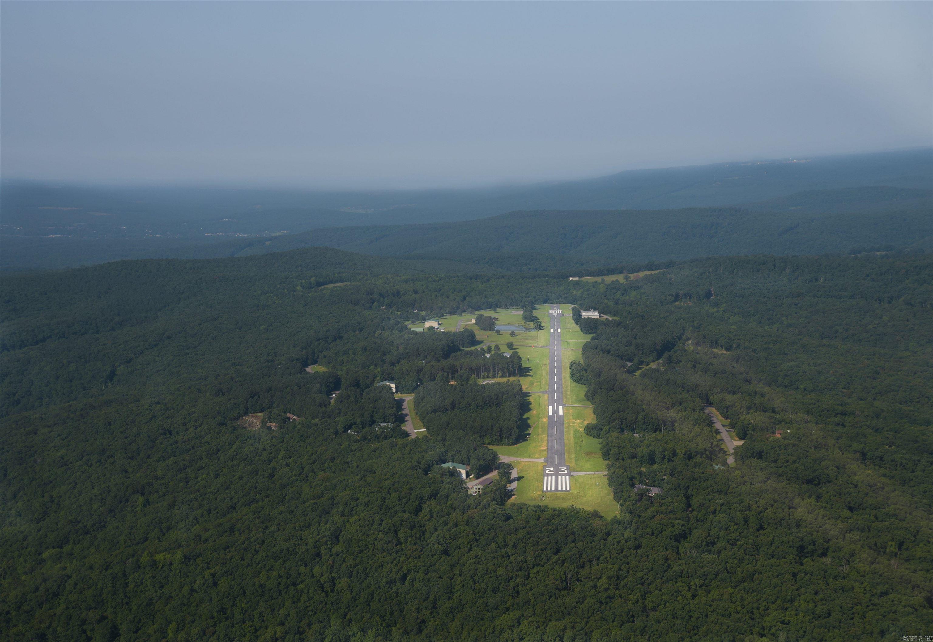 Located on the runway, this lot is the best of all worlds - a cleared area for your home and hangar, and a nice wooded area on the north side of the lot. May also have a gorgeous view of the mountains to the north if trees were thinned. Holley Mountain Airpark is a premier airpark nestled in the Ozark Mountains of Arkansas. Paved 4,800 x 50 foot paved runway, complete with two GPS approaches and pilot controlled lighting. Gated community. Close to hiking, mountain biking and ATV trails, golf courses and Greers Ferry Lake.Just a few hours from Branson & just over an hour from Little Rock. See agent remarks