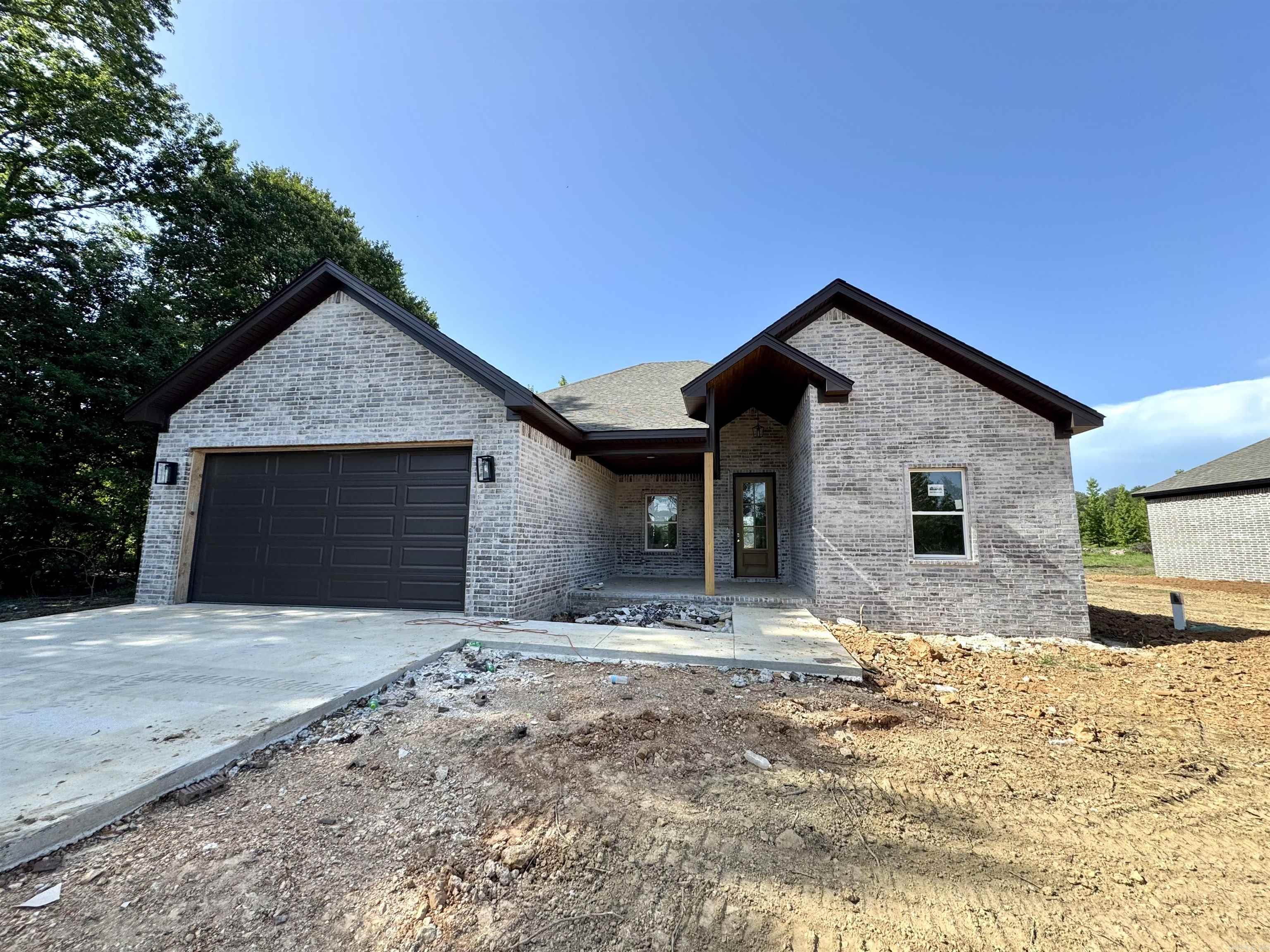 This brand-new all-brick home combines quality craftsmanship with timeless comfort. Featuring 3 bedrooms, 2 bathrooms, and 1,800 square feet of open living space, it sits on nearly an acre of land—offering both privacy and room to grow. The open floor plan flows beautifully, and the wood-burning fireplace brings warmth and charm to the heart of the home. Outside, a spacious sitting porch invites you to slow down and enjoy the peaceful surroundings. If you're looking for a move-in-ready home with space, character, and classic style, this one has it all.