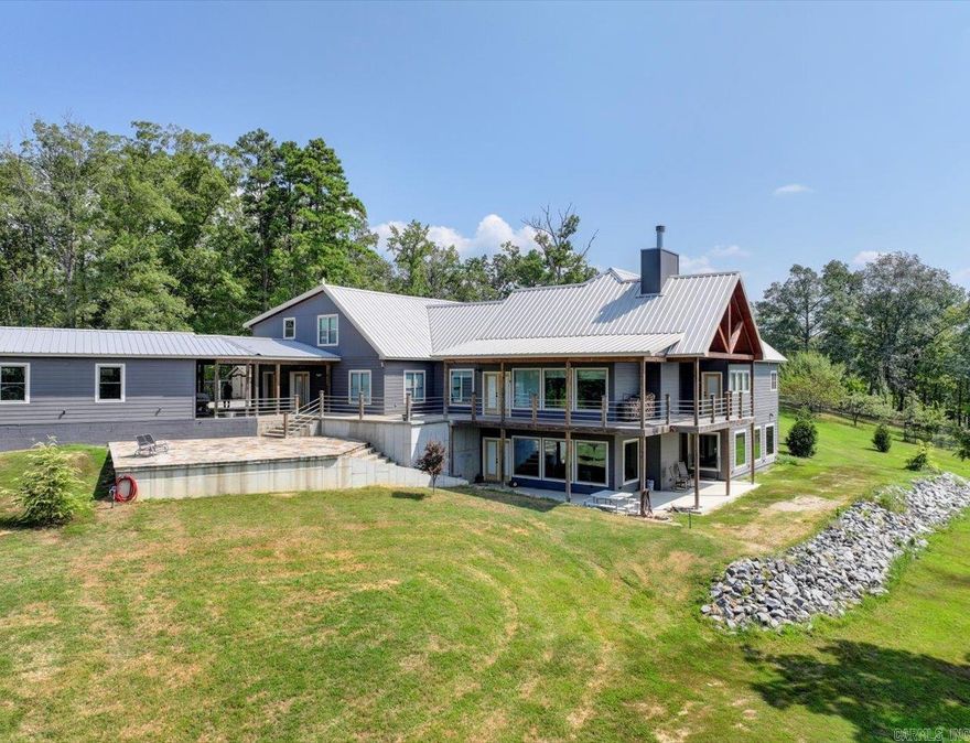 Experience breathtaking views and stunning sunsets from the deck or stone patio of this spectacular custom-built home, set on 23+ acres in the Lake Hamilton School District. This impressive 4-bedroom, 4.5-bath home spans approximately 6,079 square feet and is built for both luxury and security with 12" concrete walls, two master suites on the main level, two laundry rooms, and a safe room.   Entertain in style with a massive game room, and enjoy the convenience of a 3-car garage, an RV garage totaling approximately 2,761 square feet, and an 894-square-foot heated/cooled workshop. A whole house generator ensures you're always prepared.  Agents - Call Showing service to schedule all showings.