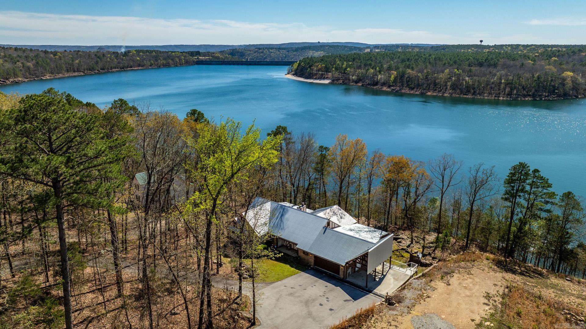 PRICE IMPROVEMENT on this stunning lakefront home boasts 6 spacious bedrooms and 2 large living areas, perfect for accommodating guests and entertaining. With over 3600 square feet of living space, there is plenty of room for everyone to spread out and relax. The property offers breathtaking views of Greers Ferry Lake and is the perfect retreat for those seeking a peaceful and tranquil setting. Enjoy the beauty of the outdoors from the expansive deck for large get togethers. This luxurious home is a must-see for anyone looking for a lakefront oasis and comes completely furnished. Subdivision also has lake access and within 5 minutes to the nearest boat launch.