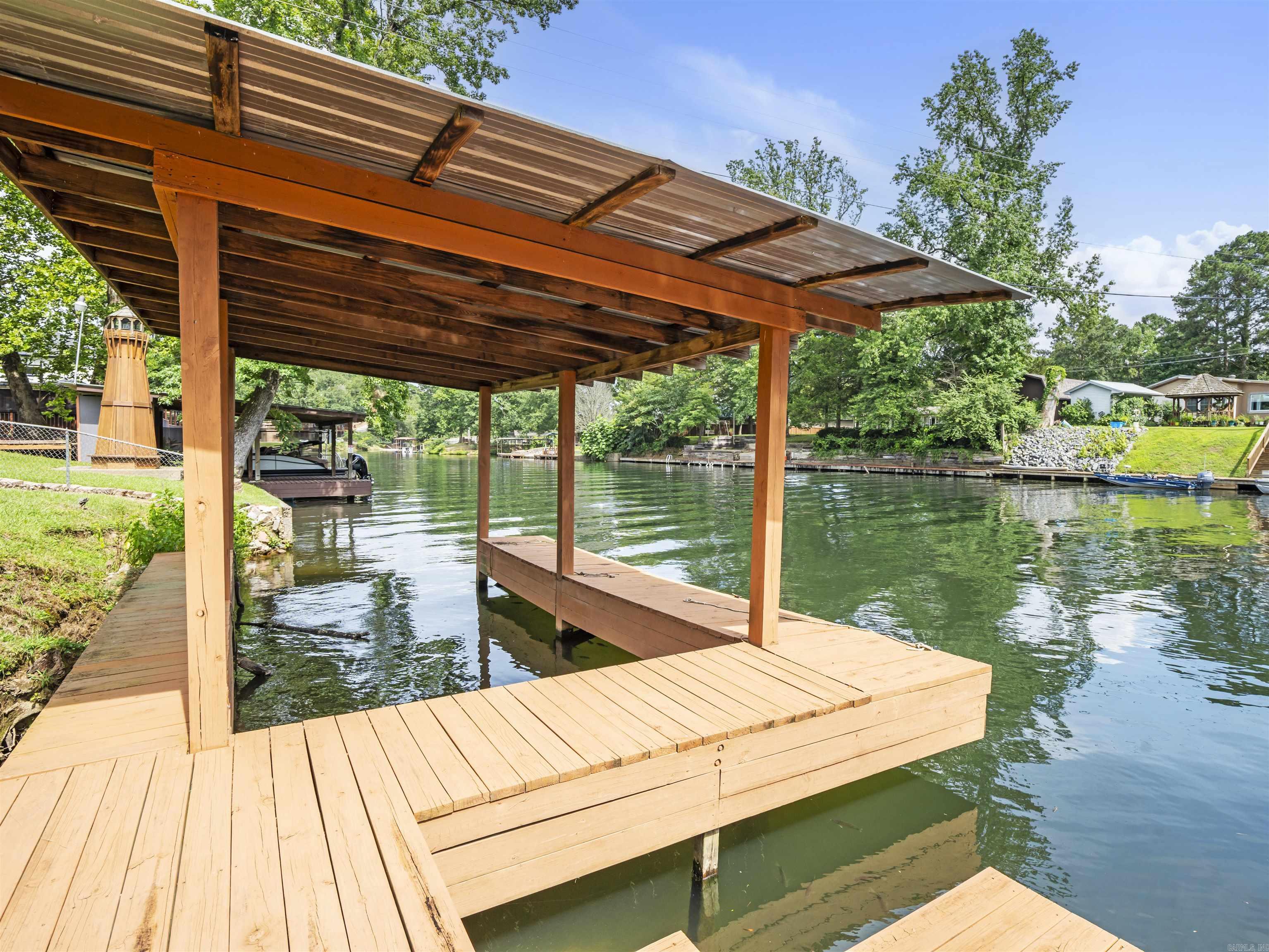 LAKE LIFE MADE AFFORDABLE!! COME COOL OFF & GET AWAY FROM IT ALL! THIS CHARMING 1 BEDROOM 1 BATH (WITH ADDITIONAL LOFT BED) LOG CABIN LOCATED ON LAKE HAMILTON JUST BEFORE THE RIVER CHANNEL AND JUST 1.5 MILES FROM LAKE OUACHITA BOAT RAMP IS CALLING YOUR NAME!! ENJOY YOUR VERY OWN PRIVATE COVERED BOAT DOCK & PRIVATE SWIM DOCK ALONG WITH PROPERTY OWNER ACCESS TO THE BOAT RAMP! YOU WILL FIND GREAT FISHING HERE! CATCH DINNER OR SIT ON THE BACK COVERED DECK AND TAKE IN THE SUN REFLECTING OFF THE WATER! IN THE EVEINING, HAVE A COLD DRINK & ENJOY THE OFF-GRID AMBIANCE WHILE LISTENING TO THE TREEFROGS AND CRICKETS, OR JUMP IN & GO FOR A SWIM! THIS IS OUTDOOR LIVING AT IT'S FINEST, BUT INSIDE IS JUST AS INVITING WITH A COZY PRIMARY SUITE THAT INCLUDES A LARGE WALK--IN SHOWER AND JETTED TUB PERFECT FOR REST AND RELAXATION OR EVEN ROMANCE! THIS COTTAGE-LIKE RETREAT MAKES FOR A GREAT VACATION HOME, RENTAL AIRBNB/VRBO OR EVEN THE PERFECT PERMANENT SANCTUARY! DO NOT MISS THIS UNIQUE OPPORTUNITY!
