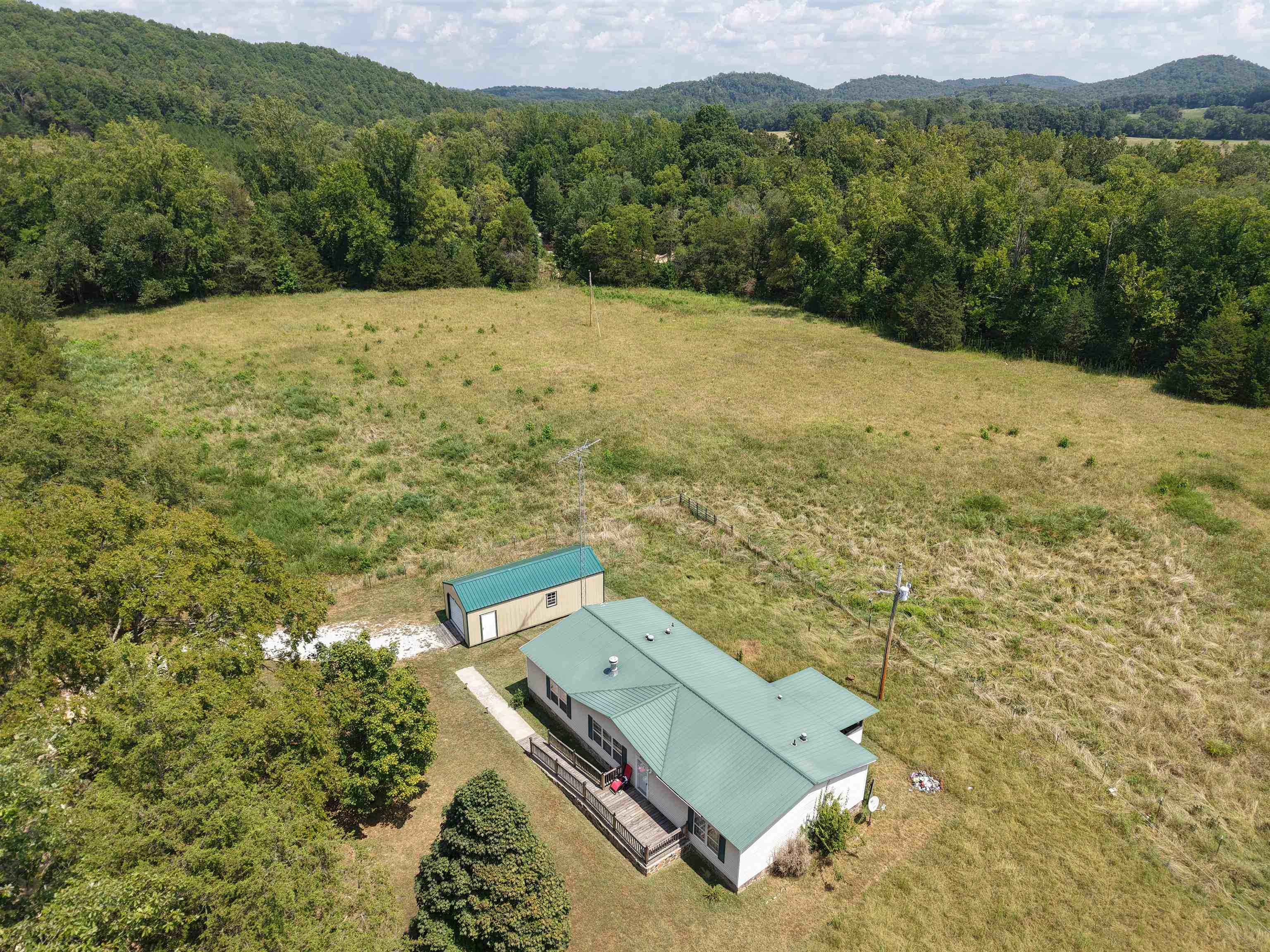 Discover country charm with in-town convenience on this beautiful 8.58 acre property along Knob Creek Road in Melbourne, Arkansas. Featuring open pasture ground with frontage on Knob Creek and a year-round freshwater creek, this property is perfectly set up for livestock or horses. This 3-bedroom, 2-bath mobile home offers comfortable living with both front and back decks to enjoy the peaceful setting. The home is complemented by a spacious Bald Eagle Barn that provides an excellent workshop or storage space. With its blend of privacy, natural beauty, and a location that feels tucked away while still close to town, this property is an ideal opportunity for those seeking a homestead, hobby farm, or a serene place to call home. Listed to sell for $199,900.