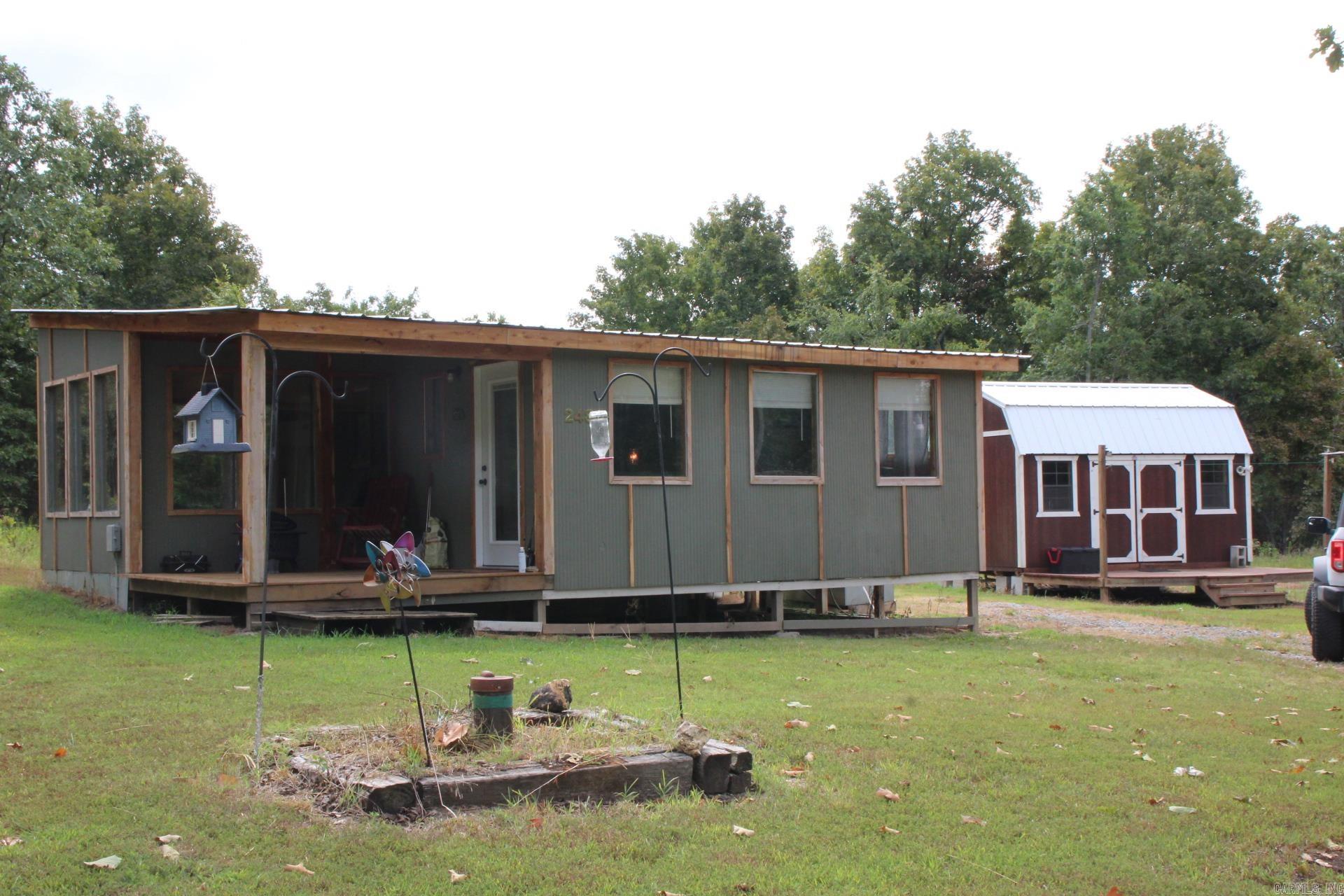 Escape to peace and privacy with this 1 bed, 1 bath home tucked away on 28.59 mostly wooded acres. Surrounded by nature, this property offers abundant wildlife, open space, and the perfect setting for a quiet country lifestyle. Charming small guest cabin complete with kitchenette and full bathroom perfect for visitors or rental potential. Chicken coop with fenced area and plenty of room for other farm animals to be self-sufficient. No restrictions. Private well for reliable water supply. Whether you are looking for a private getaway, hunting retreat, or peaceful full-time living, this property offers it all. Only minutes to Bull Shoals Lake and an hour from Branson MO.