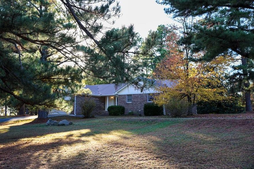 Nestled on 4.9 private acres on a peaceful dead-end road, this charming 1,745 sq. ft. country home offers the perfect blend of in-town convenience and country living in beautiful Izard County, North Central Arkansas. This low-maintenance gem boasts a durable brick exterior and a metal roof, featuring 3 bedrooms, 2 bathrooms, and an abundance of closet and storage space. The interior is designed for comfort and entertaining, highlighted by a large kitchen, a formal dining room, and a spacious living room. Step outside onto the expansive open deck, which is accessible from both the dining room and the master suite—an ideal spot for entertaining guests or simply winding down while overlooking your quiet, shaded yard filled with large trees. The property also includes all kitchen appliances, two metal sheds, a fenced garden area, and the benefit of paved road frontage in a great neighborhood.