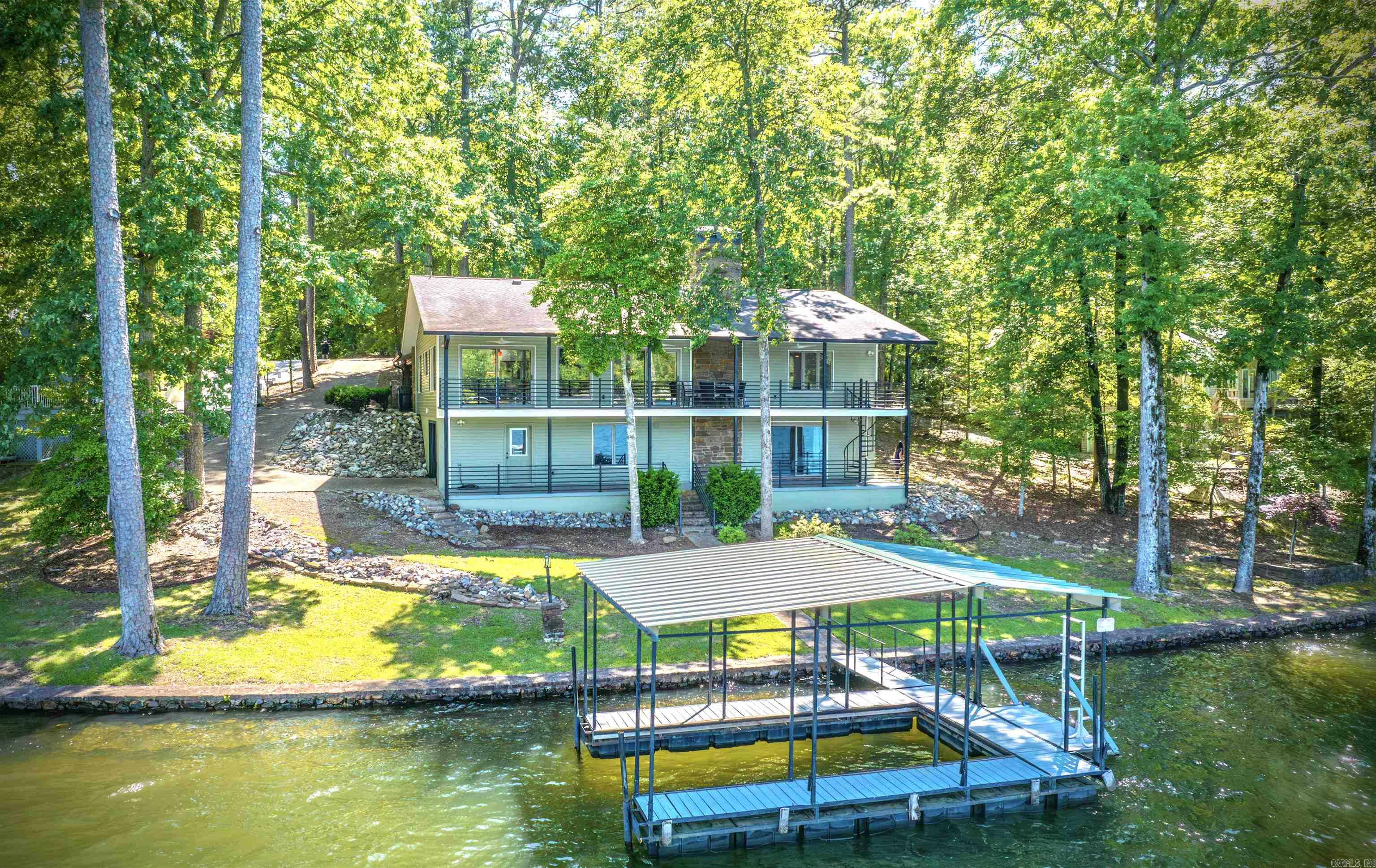 Discover this meticulously remodeled 4-bedroom, 3-full bath home with 160 feet of prime Lake Cortez frontage and expansive lake views, ideally located on a quiet cul-de-sac. Every detail has been thoughtfully updated in a mid-century modern minimalist style. Step inside to an entirely new interior, rebuilt from the studs. Luxury vinyl flooring flows throughout the main areas. The soundproofed TV room, featuring a solid door for sound reduction, offers a quiet escape. The kitchen updates include quartz countertops, all-new stainless-steel appliances, and custom cabinetry. All three bathrooms are brand new with custom cabinets. Comfort is ensured with a new HVAC heat pump. The downstairs offers a convenient apartment with a new kitchenette and a new split-unit HVAC. The exterior has a new roof, gutters, vinyl siding, fresh paint, and professional yard landscaping with new sprinklers and a lake pump. Enjoy the outdoors from a covered deck on the main level or the covered patio on the lower level. This property also includes a boat dock, a two-car carport, and a deep lower-level garage offering a workshop and loads of extra storage space.