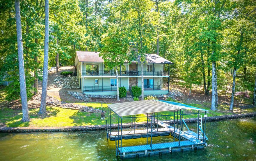 Discover this meticulously remodeled 4-bedroom, 3-full bath home with 160 feet of prime Lake Cortez frontage and expansive lake views, ideally located on a quiet cul-de-sac. Every detail has been thoughtfully updated in a mid-century modern minimalist style. Step inside to an entirely new interior, rebuilt from the studs. Luxury vinyl flooring flows throughout the main areas. The soundproofed TV room, featuring a solid door for sound reduction, offers a quiet escape. The kitchen updates include quartz countertops, all-new stainless-steel appliances, and custom cabinetry. All three bathrooms are brand new with custom cabinets. Comfort is ensured with a newer HVAC heat pump. The downstairs offers a convenient apartment with a new kitchenette and a new split-unit HVAC. The exterior has a newer roof, gutters, vinyl siding, fresh paint, and professional yard landscaping with new sprinklers and a lake pump. Enjoy the outdoors from a covered deck on the main level or the covered patio on the lower level. This property also includes a boat dock, a two-car carport, and a deep lower-level garage offering a workshop and loads of extra storage space.