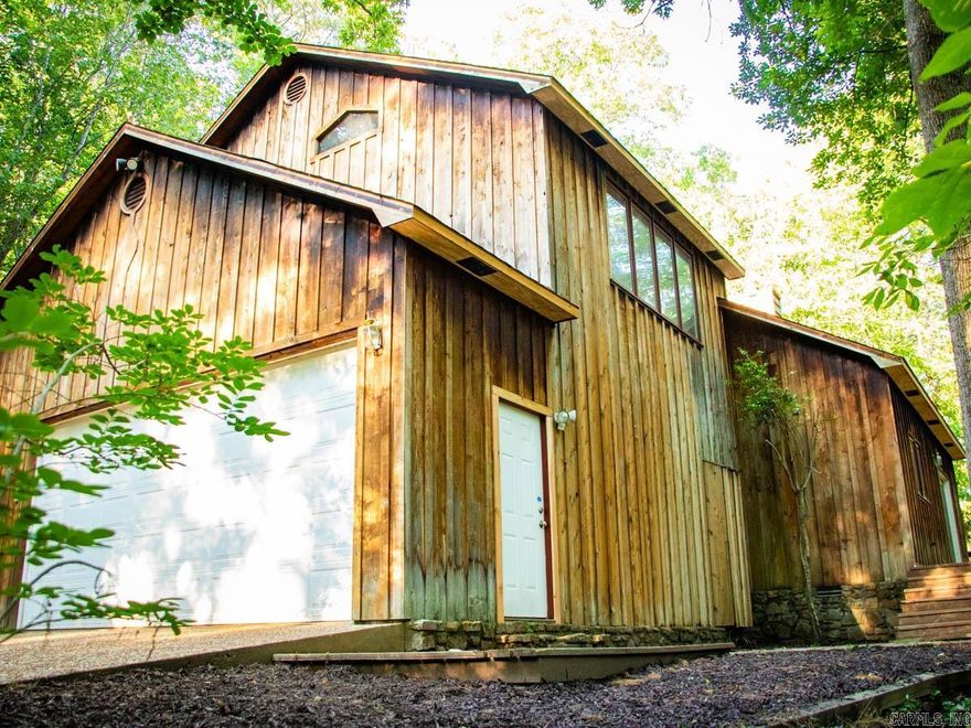 Beautiful, peaceful setting for this home on 15.5 +/- acres with creek with an additional 680 sq ft cottage.  This 2,381 sq ft home is wrapped in Western Cedar, has an open floor plan with large living/dining/kitchen area.  Vermont Castings wood burning stove will heat the entire house.  Kitchen area has tall ceiling and skylights for extra natural light.  The main bedroom is very large and includes a vaulted ceiling with wood beam, private bath and private deck with outdoor shower.  The third bedroom is open to the downstairs and makes a cozy office or sitting area but could easily be enclosed.  Lots of deck space for bird watching or enjoying the wildlife.  Extra large garage, small storage shed and fenced area with dog kennels.  Less than 6 miles to Chenal and 5 minutes drive to Hwy 10.  Come see today!  AGENTS PLEASE READ REMARKS