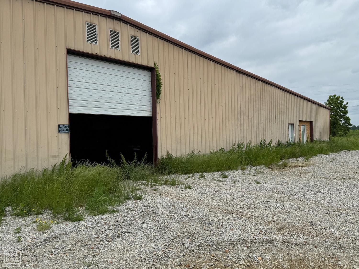 This expansive industrial facility offers 16,500 square feet of space on a 13-acre lot, providing ample room for various business operation, suitable for industrial and commercial with access for large vehicles and equipment. This property provides a solid foundation for businesses seeking space to expand or establish operations. Its strategic location and versatile infrastructure make it a valuable asset for various commercial endeavors. Inside contains and area that has been framed and plumbed for offices and bathrooms, allowing for customizable interior layouts. Call for additional information or set up a tour of the property