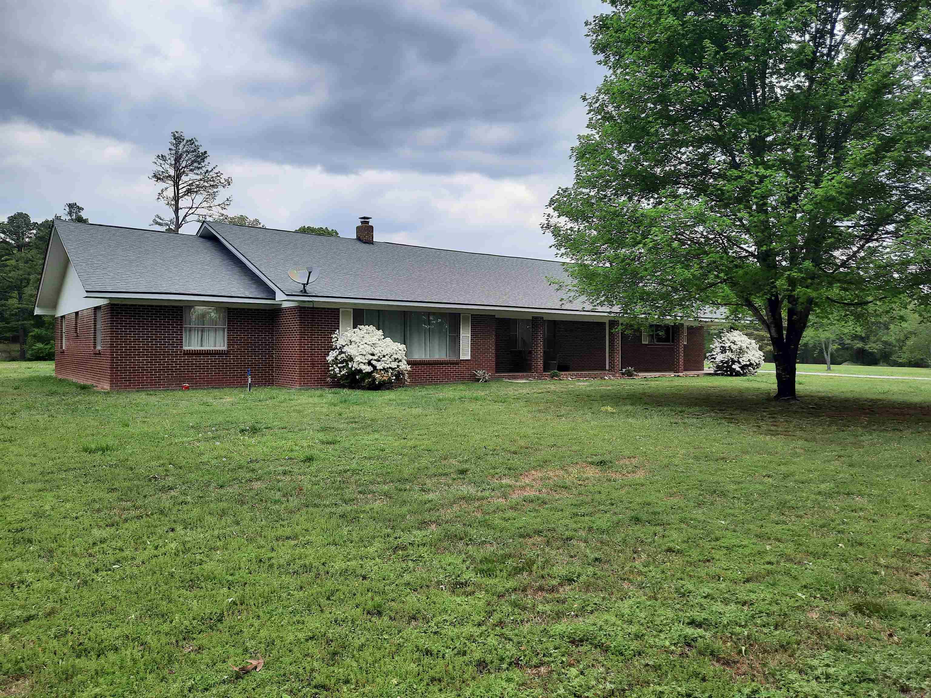 Enjoy country living just minutes from town.  This spacious brick home offers a serene setting on almost 5 acres of nice laying land, a perfect mixture of cleared land and trees, with mature shade trees lining the country driveway.  With plenty of elbow room, open concept on inside and large front and back porch to set and enjoy quiet and relaxing times. Oversized attached garage plus a large, detached shop/garage. This home has so much to offer, it's the perfect place to call home.