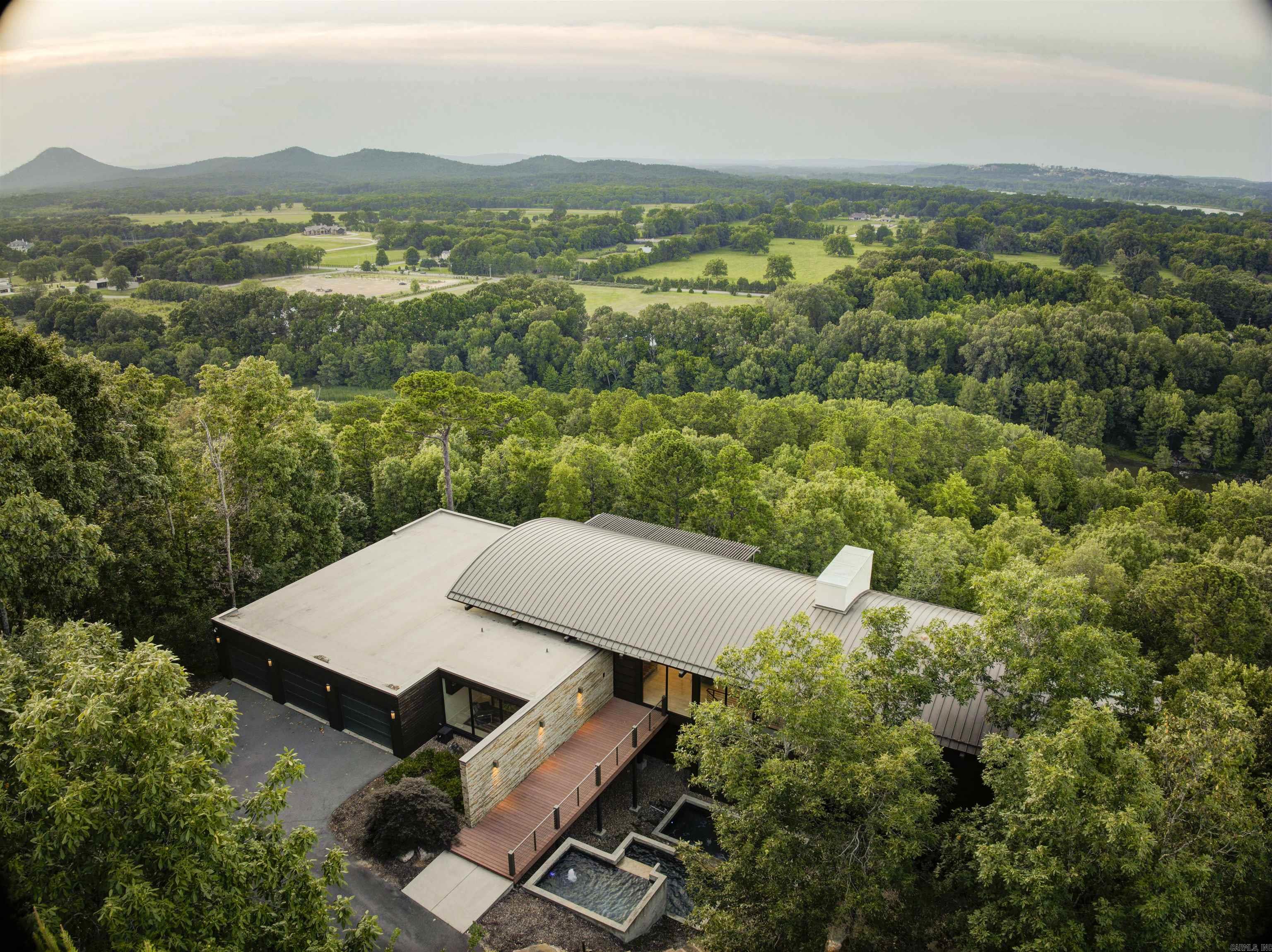 Welcome to an unparalleled living experience in the prestigious Beau Vue Estates Community of Little Rock, Arkansas. This exquisite residence, crafted in 2017 by the renowned Taggart Design and Build, effortlessly combines modern sophistication with timeless elegance. Set on over 5 acres, this home offers an exclusive escape with panoramic views that stretch as far as the eye can see. Step inside to discover a meticulously curated interior that features three spacious bedrooms, three full bathrooms, and two half baths. The impeccable architecture of this home is evident in every detail, from the expansive multi-level deck perfect for outdoor entertaining, to the two distinct living areas that provide ample space for relaxation and gatherings. The home also boasts a three-car garage, ensuring ample space for all your vehicles and storage needs. The custom furnishings, handpicked to complement the home's unique design, add an extra layer of luxury that cannot be replicated. This extraordinary property is more than just a home; it is a lifestyle. And, as an added benefit, the home is coming fully furnished, allowing you to move in and immediately enjoy the luxurious surroundings.