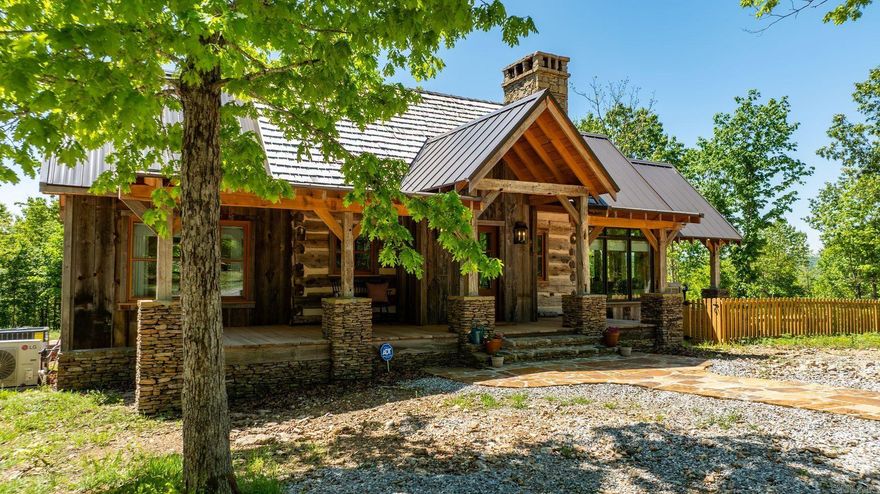Set on 94 private acres in Timbo, From Off Farm is a rare blend of history, craftsmanship, and refined rural living. Centered around a nearly 200-year-old log cabin reassembled on site and expanded in 2023, this 4-bedroom, 2.5-bath home offers 1,380 square feet with three porches designed to take in the surrounding Ozark landscape. Authentic details define the home, including traditional chinking, mahogany casement windows, reclaimed wood flooring, and custom stained glass inspired by a Bear Paw quilt pattern. The kitchen features premium appliances, marble countertops, and custom cabinetry, while baths include soapstone and Moroccan zellige tile. The land offers two clearings, established trails, and a creek with rock bluffs. A 40x60 metal building with an efficiency apartment provides additional flexibility. Gated entry, storm shelter, private well, and abundant wildlife complete this exceptional, turnkey retreat.