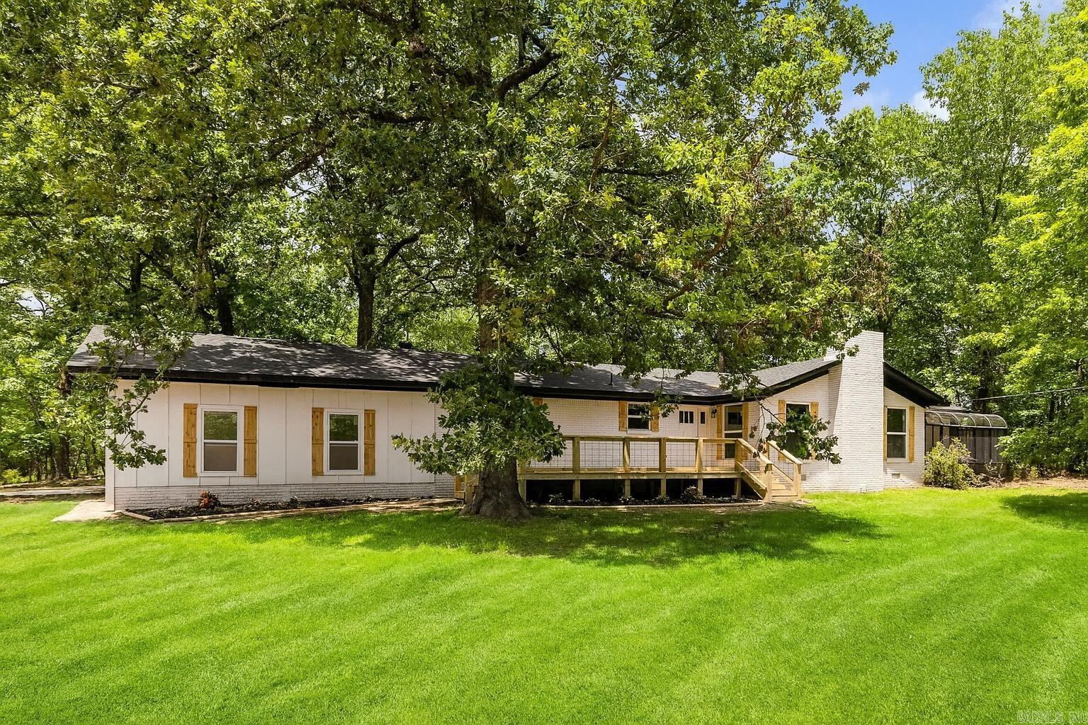 COMPLETE REMODEL ON VERY PRIVATE ACREAGE! This one level property was stripped down to the studs and everything completely replaced, including but not limited to the sheet rock, electrical, plumbing, HVAC, Roof, Windows, Doors, Interior and Exterior paint, Flooring, Lighting, Showers, Countertops, Decks, Fence, you name it! The hardwood floors are real wood and stunning. Custom Tilework for each tub and shower. Open kitchen with large breakfast area and open to living room with beautiful brick hearth and wood burning stove. The Primary suite features double vanity and large walk in closet. Heated and Cooled Sunroom would make perfect office, art studio, or playroom. Spacious Laundry room! Private lot with hardwoods, sitting in the back of a cul-de-sac. Bryant Schools!