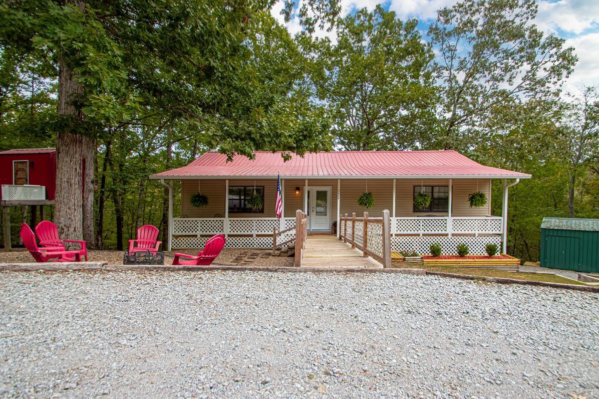 Welcome to this beautifully updated home on a peaceful, quiet road. Step inside to a tiled foyer with luxury vinyl flooring throughout. The kitchen features oak cabinets stained a beautiful dark hue and a Vent-A-Hood venting directly through the roof. This all-electric home includes a finished walk-out basement with a large laundry room, utility sink, and a spacious 2-car garage. The basement also includes an additional den and one of the three bedrooms. Built with durable 2x6 exterior walls, this home offers strength and efficiency. A circular driveway leads to the front, with a separate driveway offering access to the side-entry garage. Outside, enjoy an approximately 18x20 storage building with a loft, plus a playhouse with electricity that the seller is willing to leave behind. Relax on the covered front and back porches, with direct access from the master bedroom to the back porch. Other updates include all new electrical and plumbing, and a 26-gauge commercial-grade metal roof installed approximately 6 years ago. This home blends modern features with ample space inside and out, making it perfect for comfortable living.