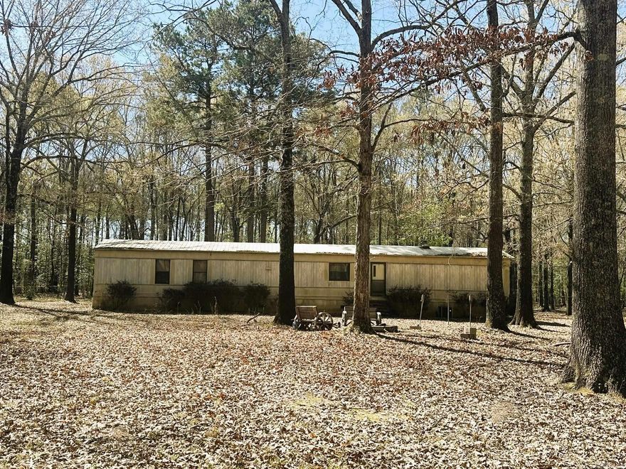 1989 Mobile Home, 16 x 80 on 7 acres.  3 bedrooms and 2 bathrooms, laminated flooring. Large primary with double vanity and garden tub - separate shower.  Washer and Dryer in kitchen closet will convey along with the refrigerator. Beautiful piece of land with crepe myrtles, blueberry bushes, fig trees and wildlife all around.  City water but does have a well still in place. Prophane tank is owned by seller.