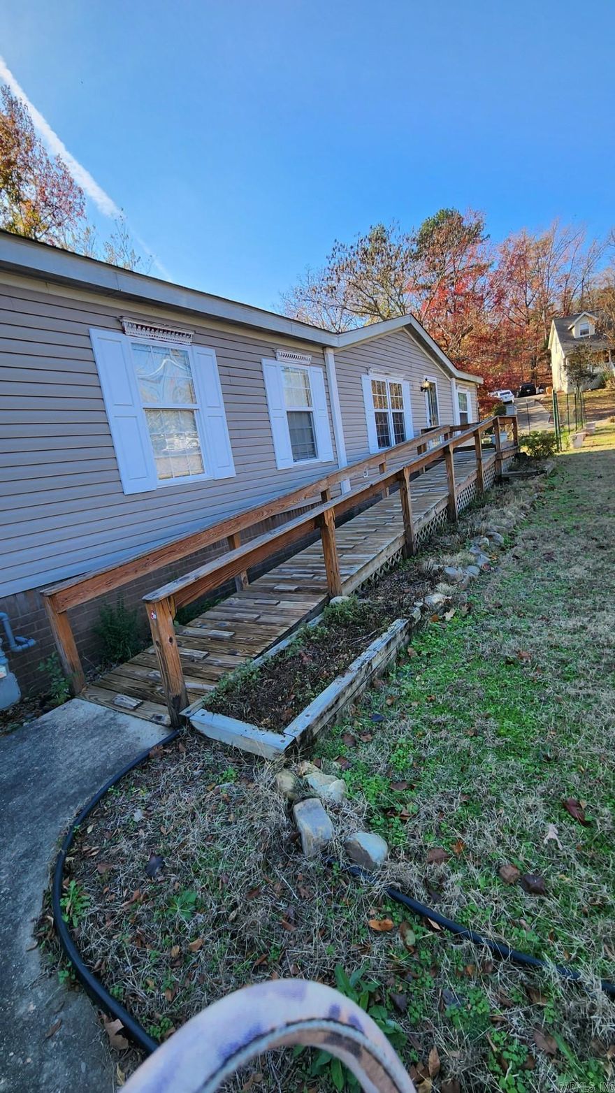 This manufactured home was adapted to accommodate handicap person in a wheel chair. Kitchen cabinets(Custom) lowered, bathrooms, walk in shower. Even has a garage (with space for workshop) attached to the home, with a ramp into utility room. Out door ramps to yard (front and back.) It is on a permanent foundation (as per Seller.) 3 bedroom, split floor plan, 2 bathrooms. Nice wood floors in living, dining, kitchen, and bedrooms. Fresh paint, new flooring in master bath, utility, 2nd bathroom. An abundance of cabinets in kitchen for storage. Nice pantry! A total of 7 ceiling fans, wbfp in living room, faux wood blinds, tilt in windows for ease of cleaning. New roof 2020.