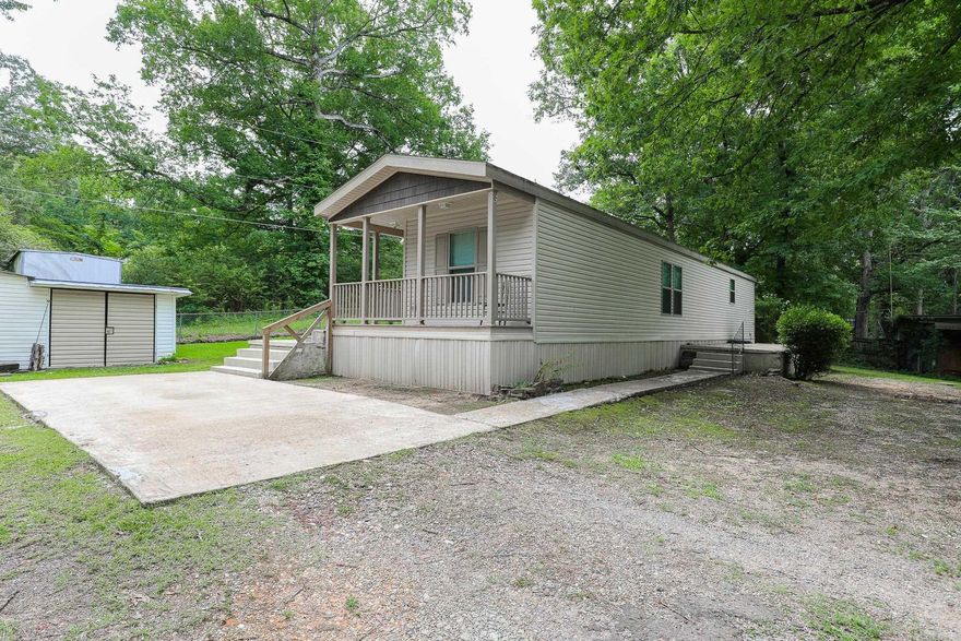 Walk up the solid concrete stairs onto a small side porch that leads into a well maintained mobile home that sits off the road. Bedrooms are on opposite ends with their own bathrooms, with walk-in closets for privacy.  Open floor plan, for entertainment.  Has a nice covered deck area on the back side of the mobile that is good for entertaining.  Three storage building to house all your extra toys.  Agents please read remarks.