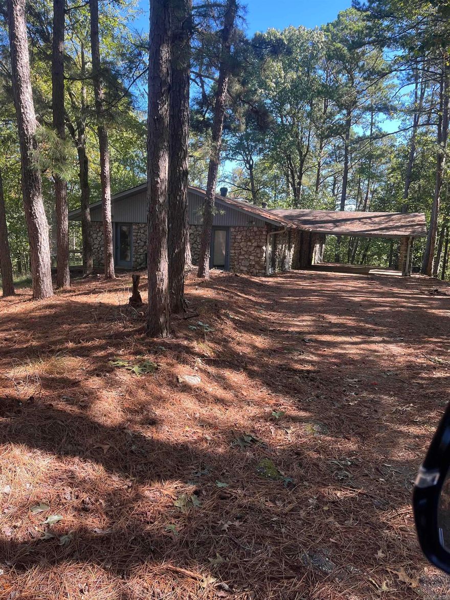 This home needs work but has much potential.  Located on 10.3 acres in Lake Hamilton School District it is situated on a mountain with a view.  It features a large stone fireplace with a wood burning stove in a large open living room.  It also has a pool with a wooden deckl.