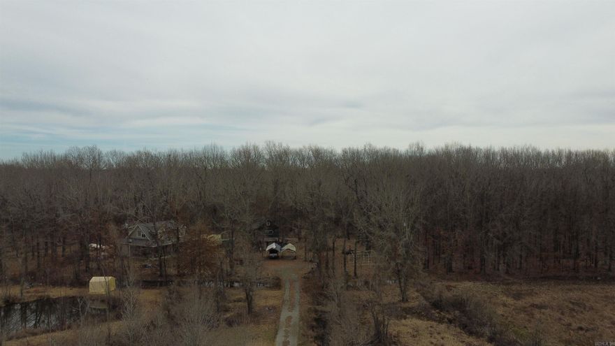 Diamond opportunity to own a mini ranch custom built home with built in storm shelter wonderful large porch for the country quiet evenings main house boasts over 1800 square foot with an additional in law quarter or shop with frame straightener built into the re-enforced concrete bottom floor.  Wonderful mature trees with a big pond perfect swimming or fishing in the warmer months. Long private drive in the county no restrictions currently on well and all electric city water and gas available at buyers choice and expense across the road.