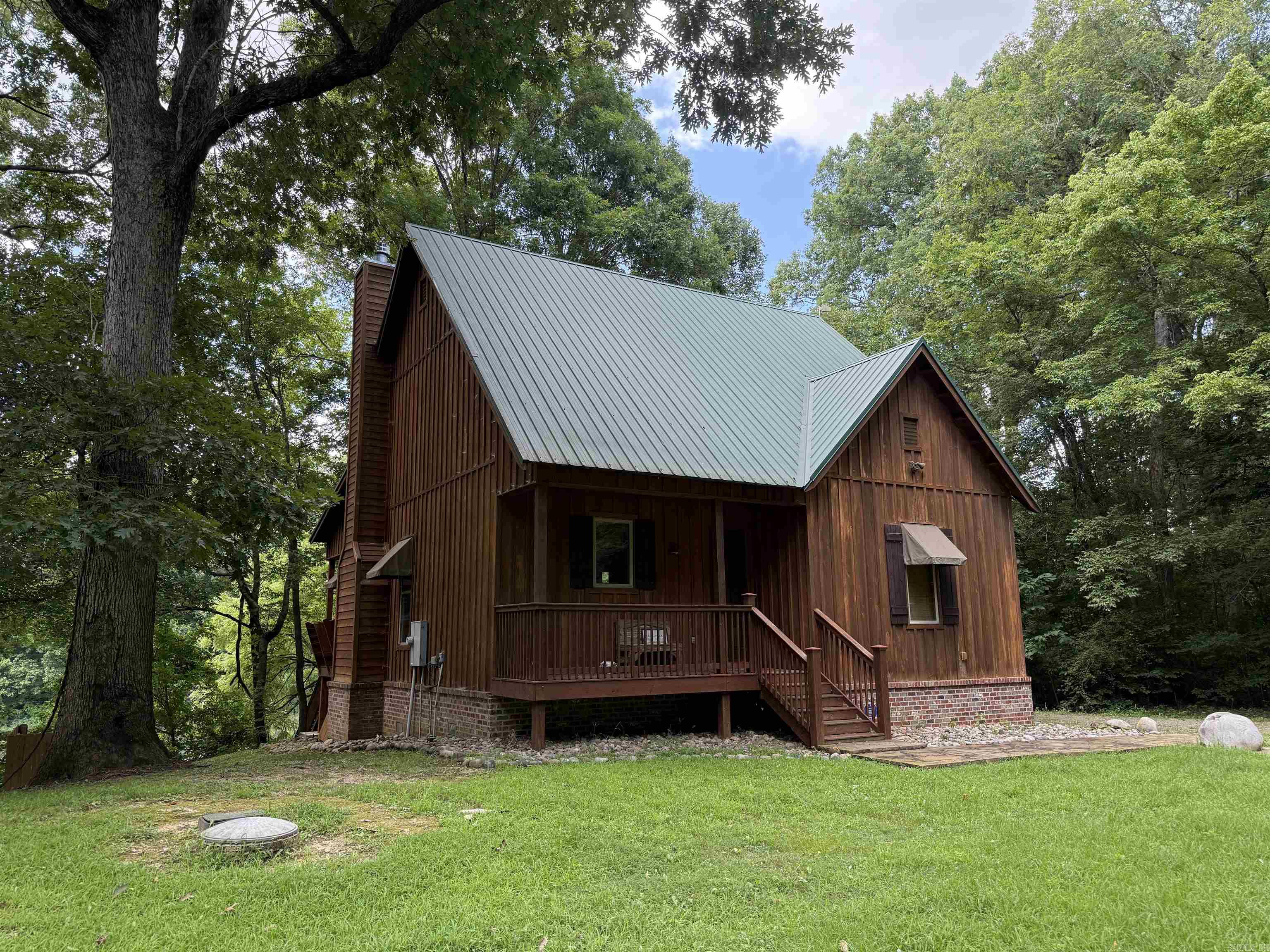 Here's your cabin on the Little Red River--one of the premier trout streams in North America. Rustic feel with modern comfort. Pine plank floors in the great room, heavy beams in the ceiling, craftsman style woodwork throughout the interior. Lots of glass for great views of the river from the common area and the primary bedroom. Multiple great outdoor spaces, patios and decks, built-in Big Green Egg for entertaining, modern dock with power boat lift. House comes nicely furnished, all appliances convey--just bring the groceries and fly rods! AGENTS SEE REMARKS!