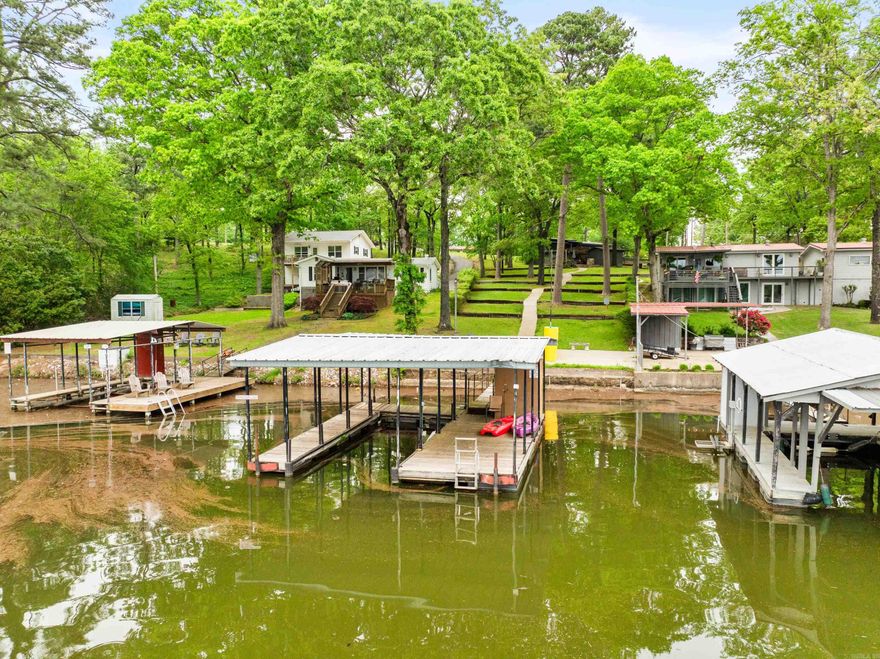 Well kept and clean lake home. Main channel view, covered boat dock with swim platform. 3/2/1, Main level has 2 bedrooms, 1 full bathroom and 1 half bathroom, living room, dining, kitchen and utility room. Lower level has lake view, 1 bedroom, 1 full bathroom, living area and sitting area used for twin beds currently. Master has a lake view. Upper living has a fireplace with electric logs. Tankless gas hot water heater. Washer, dryer and refrigerator convey. Furnished with a few exceptions, list of exceptions available. Circle drive, carport, storage building, metal roof. Patio with fire pit and deck have lake view. Seawall, patio by the lake, concrete walk to the lake. Corner lot,  Snapper riding mower and sweeper are negotiable. Survey and flood elevation certificate on file.