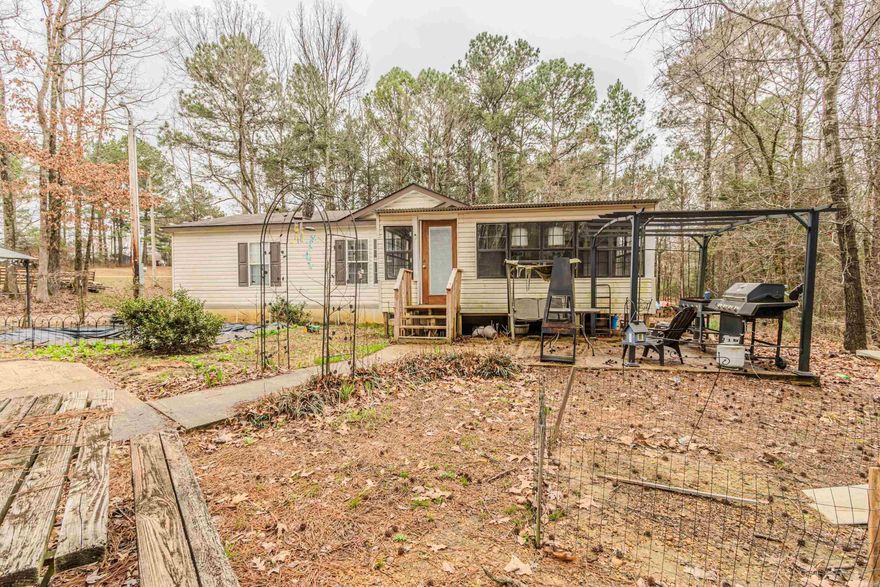 Looking for country living?  This 3 bedroom, 2 bath manufactured home offers 1,344 sq.ft. of heated and cooled living space, thoughtfully designed with a split floor plan for privacy and functionality.  The heart of the home is the spacious kitchen featuring a large center island perfect for gathering and entertainment. The open layout flows comfortably into the main living area, creating a warm and inviting atmosphere.  The primary suite includes a relaxing garden tub, separate shower and generous space to unwind.  This all electric home sits on 1.92 acres. It includes a 24'x30' metal shop building with storm shelter, a 12'x16' storage building, 2 car detached carport, and 2- 30/50 AMP RV hookups with chat parking.