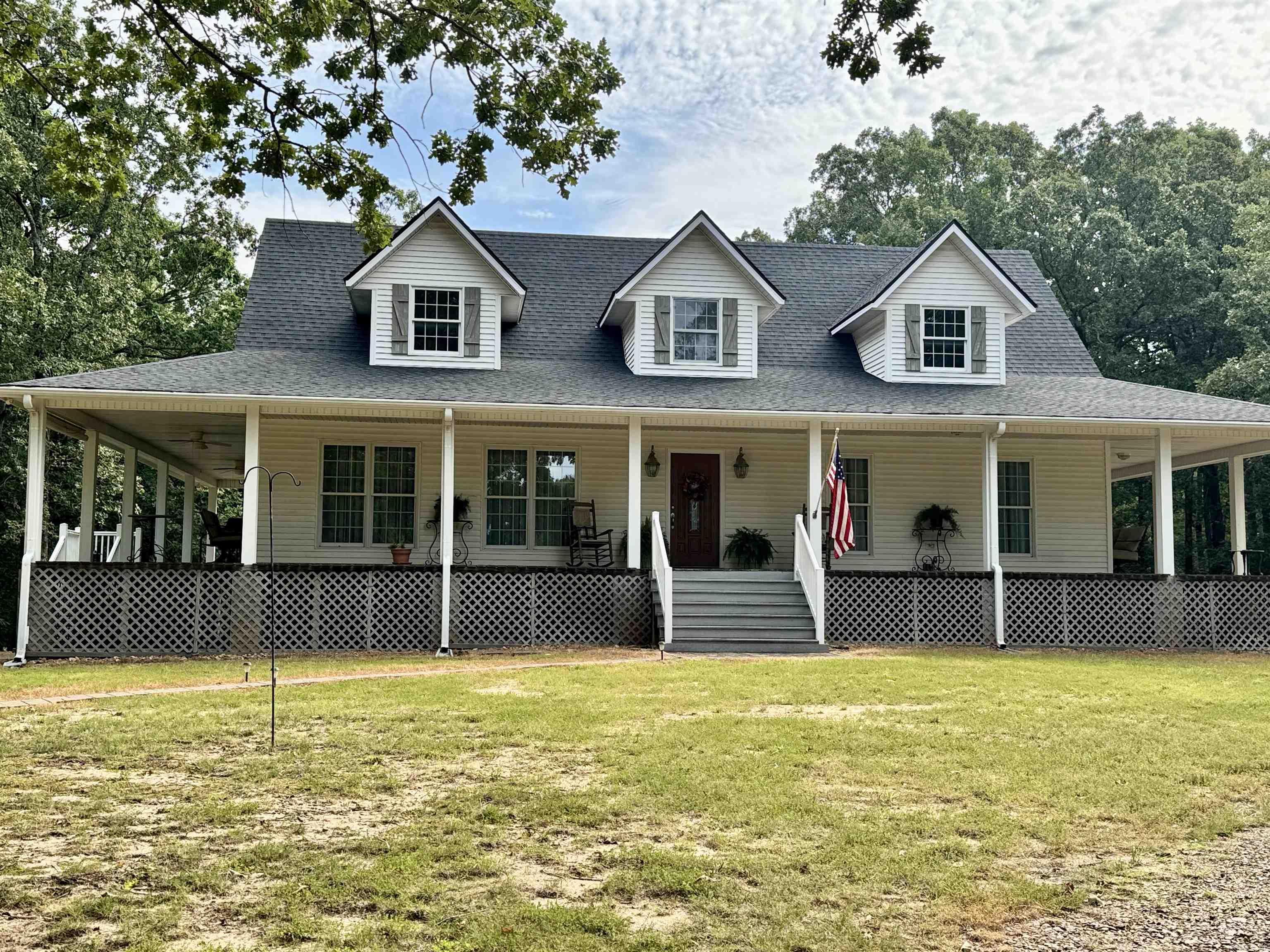 As you start up the cyprus tree-lined driveway, you'll see a sprawling pasture on the left, but at the crest of the first hill, you're looking at majestic old trees everywhere. Then, as you round the last curve--home! This custom-designed farmhouse, with wrap-around porches on all four sides, is the ultimate quiet and relaxing retreat. Nestled at the top of 22.75 acres of lush rolling hills, flatland, and nature's beauty, the house welcomes you inside or invites you to drop what you're doing and stay outside and sit awhile on one of the four 9-ft wide porches. On any given day, you're likely to see deer, squirrels, birds of every kind, wild turkeys, rabbits, and an occasional fox or ducks on the pond. The tear-drop shaped pond has a dock for fishing or just watching the world drift by. The entire estate is like a little slice of heaven on earth, and a once-in-a-lifetime unique property. NEW ROOF!