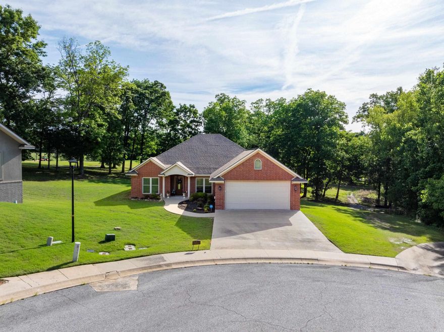 Beautiful 3 bed, 2 bath brick home on the golf course in The Village at Eagle Mountain, located on a quiet cul-de-sac on Valley View Road in Batesville, AR. Overlooking Hole #3, this home offers great views and a peaceful setting just minutes from White River Medical Center, shopping, and dining. Inside, you’ll find a bright, open layout with a vaulted ceiling in the living room, gas log fireplace, and plenty of natural light. A dining area sits just off the entry, while the galley kitchen with breakfast area overlooks the golf course and leads to a covered back porch and patio, perfect for relaxing or entertaining. The split floor plan includes two guest bedrooms and a full bath with double sinks on one side, and a private primary suite on the other featuring a custom bathroom with double sinks, vanity area, walk-in shower, private toilet room, and large walk-in closet. Additional features include laundry room with sink and storage, custom wood blinds, natural gas, sprinkler system, sump pump, attic storage with stair access, and a 2-car garage. Built in 2012, this well-maintained home offers comfort, quality, and a great golf course location.
