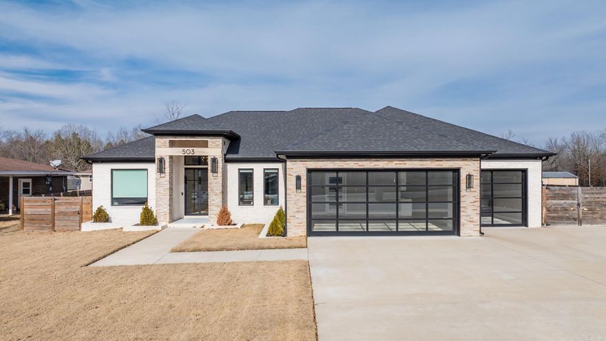 Welcome to this Exceptional Beauty where unparalleled craftsmanship meets elegant design.A custom brick & stacked flagstone rock exterior set the tone for this exquisite property,surrounded by brick flower planters that enhance its curb appeal.Exterior Features:3-car garage w/custom glass garage doors,Extra driveway,Detailed entrance w/glass iron double doors & wood-lined porch ceiling,Gutters & Horizontal planked wood fence for privacy. Interior:Wood plank-style ceramic tile flooring,custom lighting,12' ceilings in entry,stacked flagstone rock wood-burning fireplace w/custom wood-style mantle that cleverly conceals electronics,a wood beam-lined opening that connects seamlessly to the kitchen area,leathered granite countertops,floor-to-ceiling custom cabinetry,under cabinet lighting,antique tile backsplash,wood-lined vent hood,Stainless appliances,walk-in pantry & Office/4th Bedroom w/glass iron sliding entry door.Patio:approx. 14’3”x26’ w/wood-lined ceiling,cypress wood columns,stacked flagstone rock exterior wood-burning fireplace w/gas starter & wood mantle.Additionally, there's an exterior double bay metal storage building on a concrete slab w/workbenches & a walk-thru door