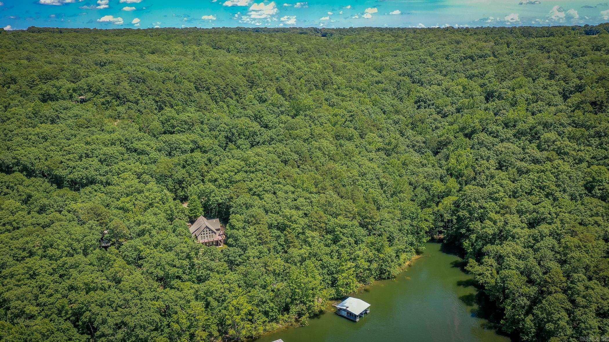 Stunning Lakefront Retreat with Private 2-Stall Boat Dock on Greers Ferry Lake. Welcome to your dream lakefront oasis! Nestled on a tranquil stretch of Greers Ferry Lake, this remarkable home offers the ultimate blend of relaxation, recreation, and luxury lake living. Featuring a private 2-stall boat dock, you’re ready for all of your water adventures right outside your door—whether it’s boating, fishing, swimming, or simply soaking up the peaceful views. This beautifully designed residence boasts 4 spacious bedrooms and 4 full baths, making it perfect for hosting family and friends. The main living area impresses with soaring vaulted ceilings, custom solid wood doors, and an inviting open floor plan designed for both entertaining and everyday comfort. Enjoy morning coffee or evening sunsets on the expansive wrap-around deck, where you’re treated to panoramic views of the lake and the serene, tree-lined surroundings. Whether you’re hosting a barbecue or unwinding with a good book, this outdoor space is sure to become your favorite retreat. Located on a quiet, sought-after part of Greers Ferry Lake. Could be sold fully furnished. Schedule your private showing today.