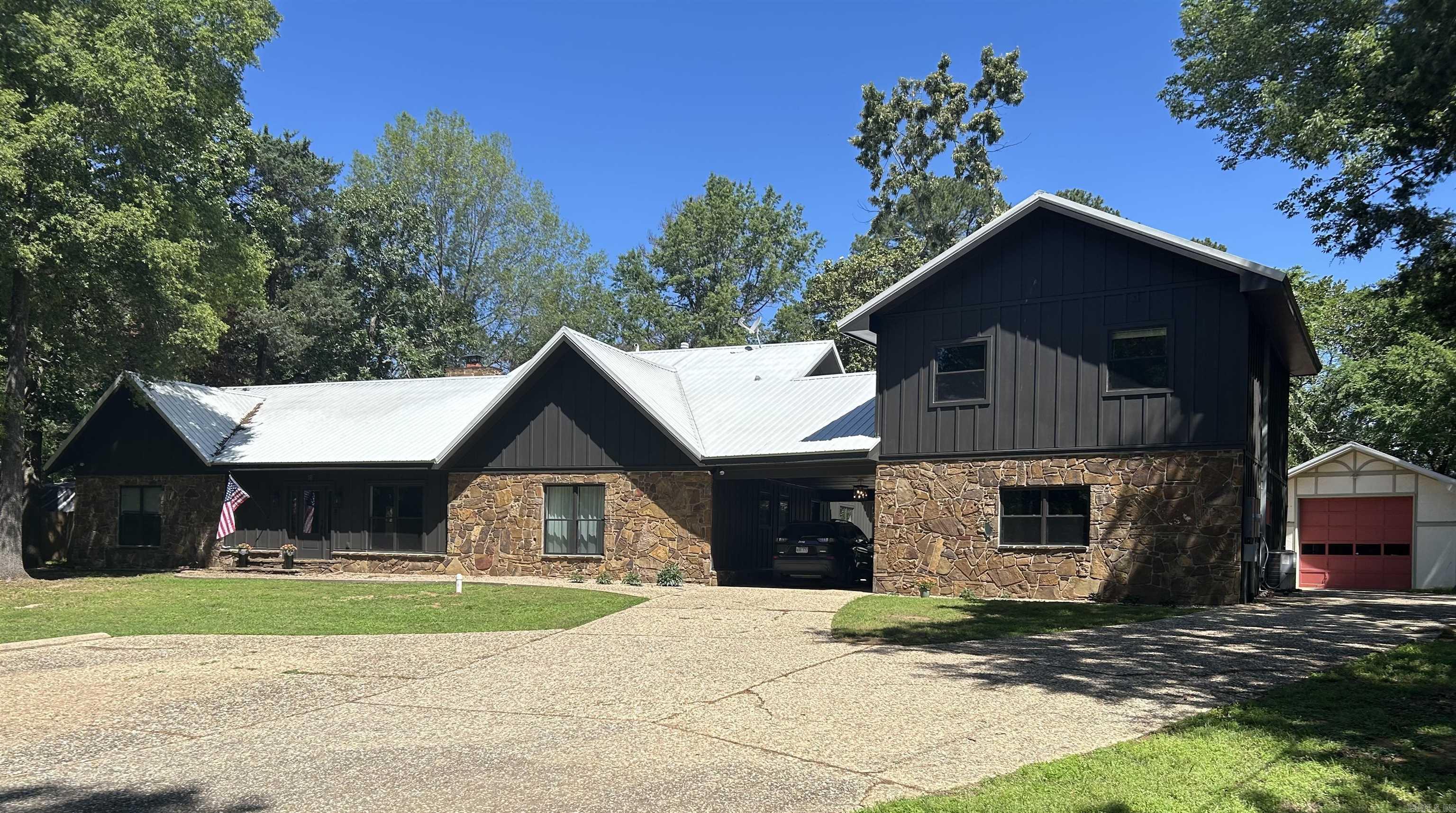 Country Living in the Heart of Conway — 2.5 Acres with Endless Potential! Enjoy the peace of country life in the heart of Conway on this spacious 2.5 acre property. The 3,080 sq ft main home is full of charm and character, featuring a stunning floor-to-ceiling stone wood-burning fireplace, a cozy pit-style living room, and a unique indoor planter that brings the outdoors in. With 3 bedrooms, an office, bonus area, and 3 bathrooms (2 with preserved vintage flair, 1 ready for your personal touch), there’s room for everyone to make it their own. Recent upgrades include beautiful new Hardie board siding, soffit, fascia, Marvin windows flooding the home with natural light, new exterior doors, and updated lighting throughout. The metal roof and energy-efficient improvements make the home cost-effective year-round. All new electrical panels (2023), including an RV hookup, plus city sewer and privacy fencing added in 2024. Attached via the carport is an additional 1,418 sq ft living space with 2 bedrooms, 1 bath upstairs, laundry hookup, and a large open-concept area below — perfect for a gym, or game room. Outside, enjoy mature trees, gardening space, an 800 sq ft shop with high ceilings