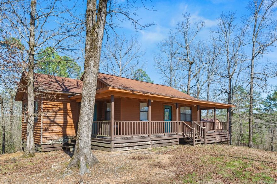 Ten acres with an adorable two bedroom cabin on a hilltop.The cabin has two bedrooms, one bath, wrap around porch with deck and a spacious living room.  The kitchen has custom built cabinets, rustic cedar countertop, cedar beams and more.  There is a small dining room too.  The property is mostly wooded and there are two small streams on the land.  This would make a great get away/weekend property and would be a great vacation rental too.  The property is not far from the Ouachita National Forest.  There is a storage building, a small game dressing shed, cook shack and more.  Don’t wait, this is the cabin you have always wanted!