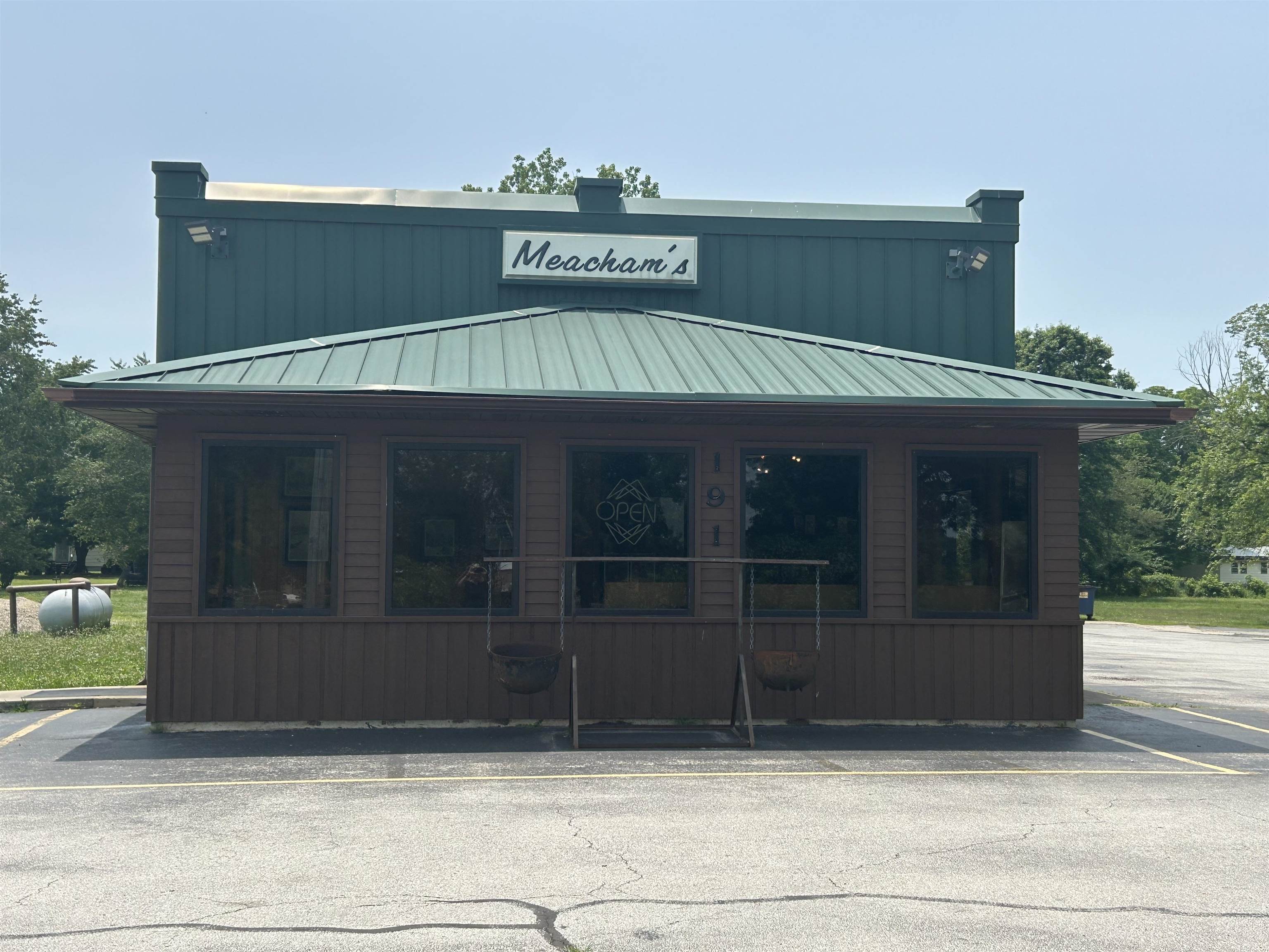 This commercial property sits on 1.5± acres with approximately 250 feet of highway frontage, offering easy access and excellent visibility in a high-traffic location. The 2,000 sq ft building, formerly operated as a beloved family restaurant, features a metal roof and a blend of wood and vinyl siding. Positioned on a mostly level lot, it includes paved parking for 35+ vehicles. Inside, enjoy a comfortable waiting area and a spacious dining room with a beautiful vaulted ceiling that seats approximately 50 guests, furnished with booths, tables, and chairs. The building is equipped with commercial kitchen equipment, two HVAC units, and a combination of concrete, tile, and wood flooring. Additional amenities include two customer restrooms, a private employee restroom, and extra parking for staff. This versatile space is ideal for a restaurant, retail shop, or service-based business looking to thrive in a prime location. (Measurements are approximate.)