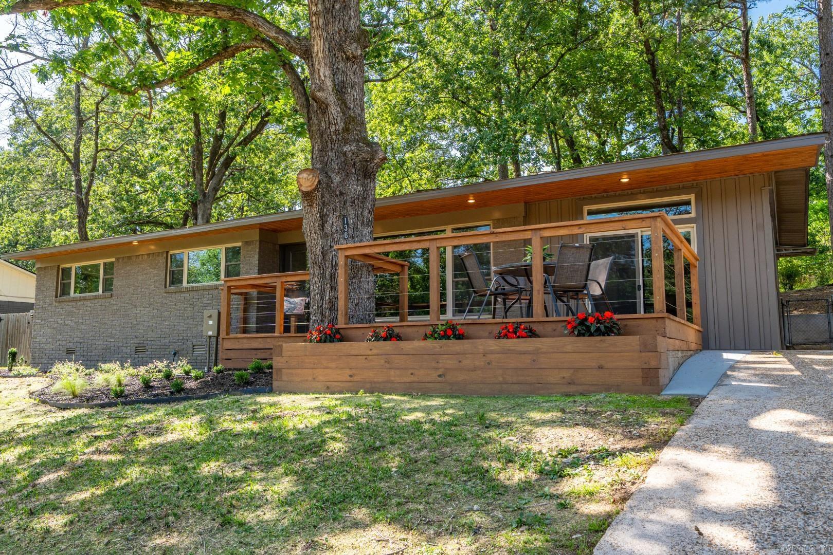 136 Buster Reed Drive offers stylish, modern living with an unobstructed lake view and a 18' dock directly across the street. This professionally renovated modern ranch features generous decking, wire railing for a seamless view, tongue & groove accents, and fresh landscaping for standout curb appeal. The front yard was recently hydroseeded for a lush lawn in no time. The fenced backyard and patio are perfect for pets. Inside, enjoy an open-concept living/kitchen area, large dining/entertainment room, 3 bedrooms, 2 baths, and a spacious laundry room. Primary suite has oversize walk-in closet and walk-in shower. Water views are visible from the living room, kitchen, dining, and two bedrooms. High-end finishes include custom tile, walnut & quartz countertops, refinished hardwoods, stainless appliances, ambient lighting, and curated fixtures. Updates include new HVAC, roof, electrical, plumbing, cabinetry, windows, decking, and retaining walls. The permitted 18' floating dock (6' water depth as of 5/16/25) was recently re-decked. No surprises here, this property is just as beautiful in person as it is in the photography. Ask your realtor for the full list of upgrades!
