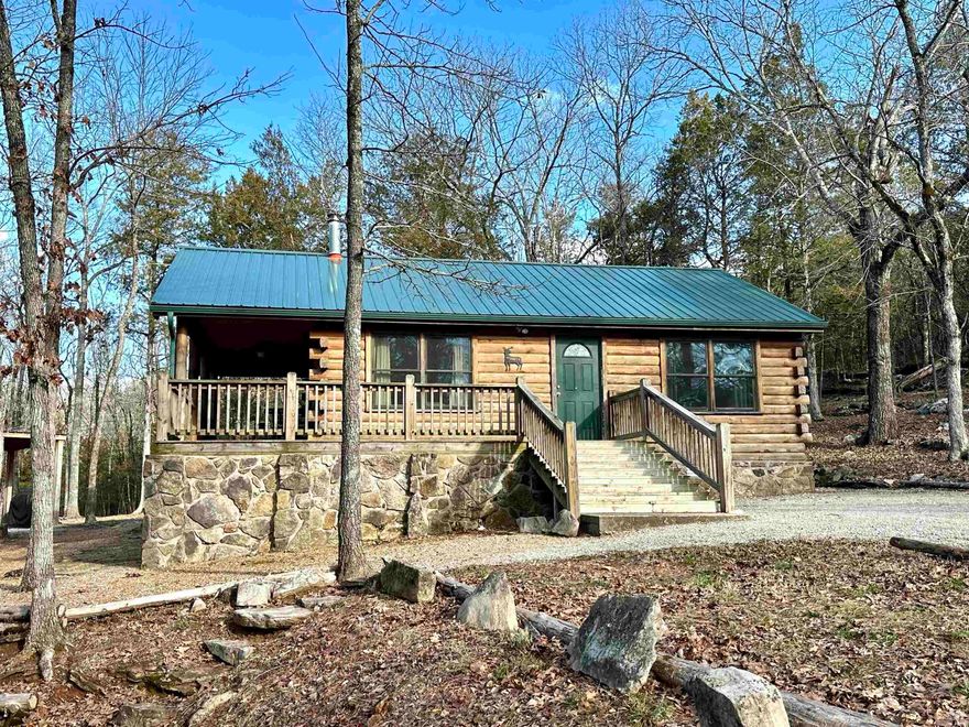 Private, Log Cabin in the Ozarks! This property consists of 10.85 acres bordering Arkansas Natural Heritage property. The cabin features an open floor plan with 2 bedrooms and 1 bathroom. Minisplit unit for heating & cooling along with propane heat. All appliances convey and a new roof was just installed!  Throughout the property there are several hiking trails to enjoy large rock formations, mossy glades, & a seasonal creek. Property is currently being used as a vacation rental, but could be a great getaway cabin or retreat for the family!  Located 2 miles from the White River!